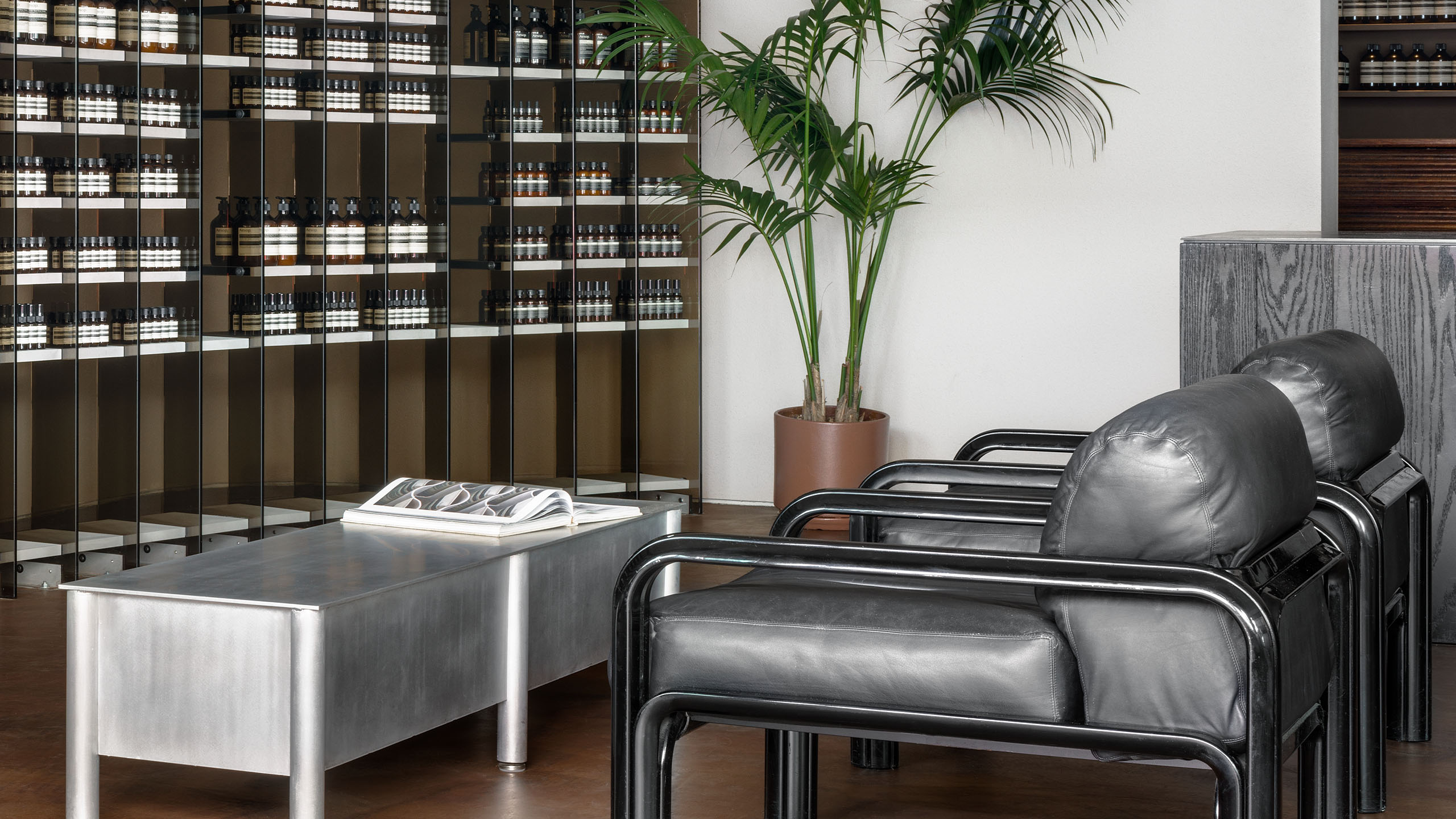 The black glossy enamelled metal frames of bold 1970s armchairs