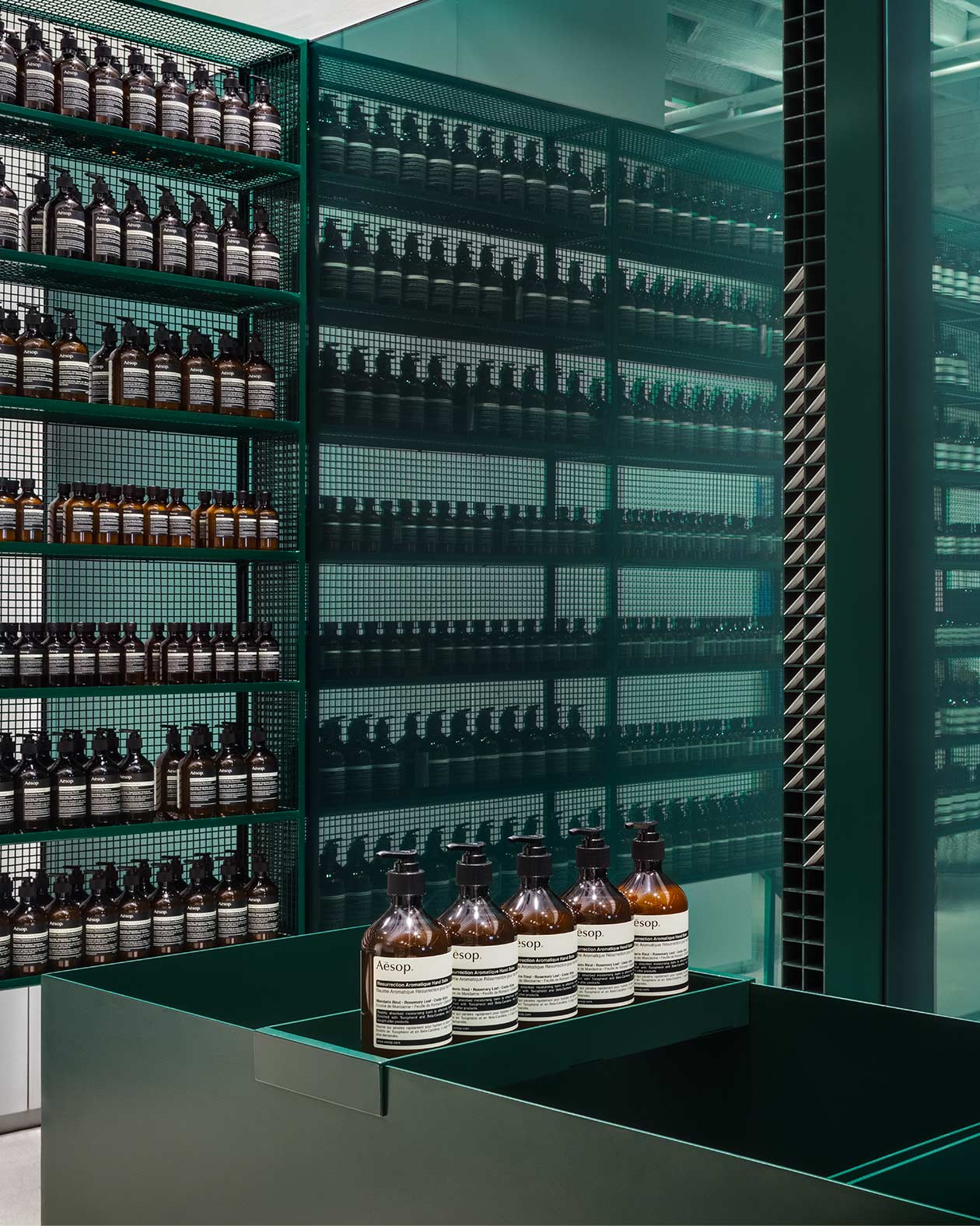 A teal, coloured steel shelf holding Aesop product