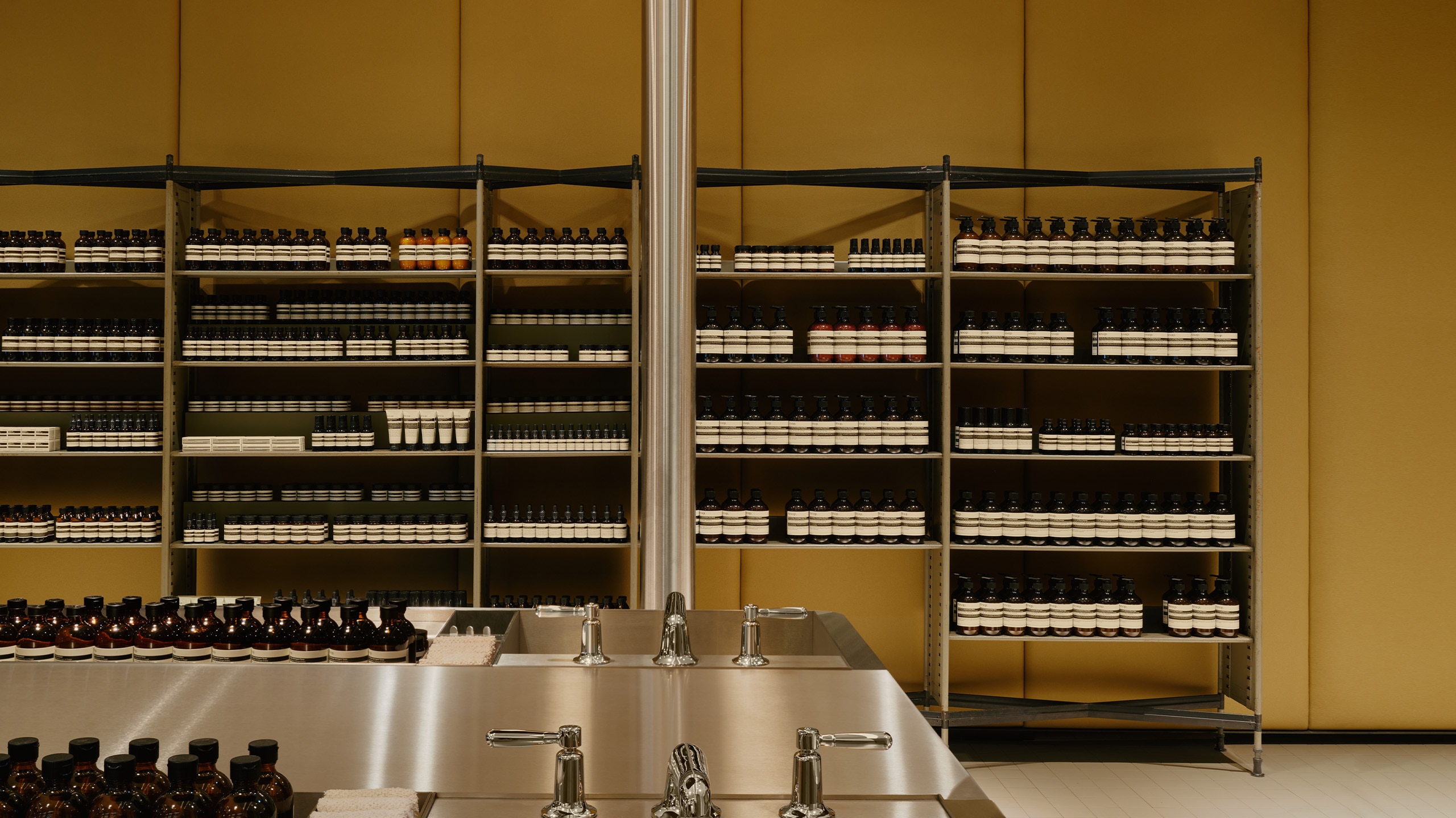 Aesop Sendlinger Strasse store interior featuring product displays in amber bottles neatly spaced on displays shelves.