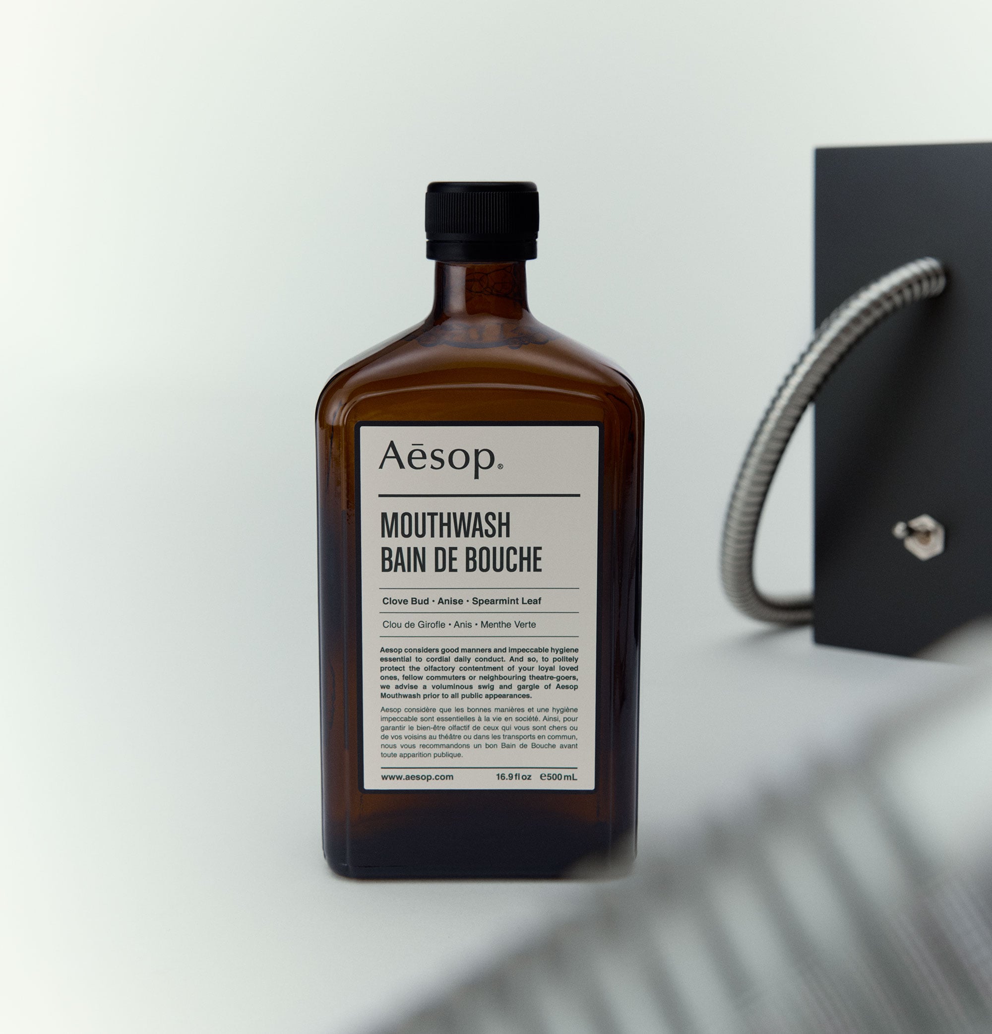 Aesop Mouthwash in amber bottle arranged on a white background