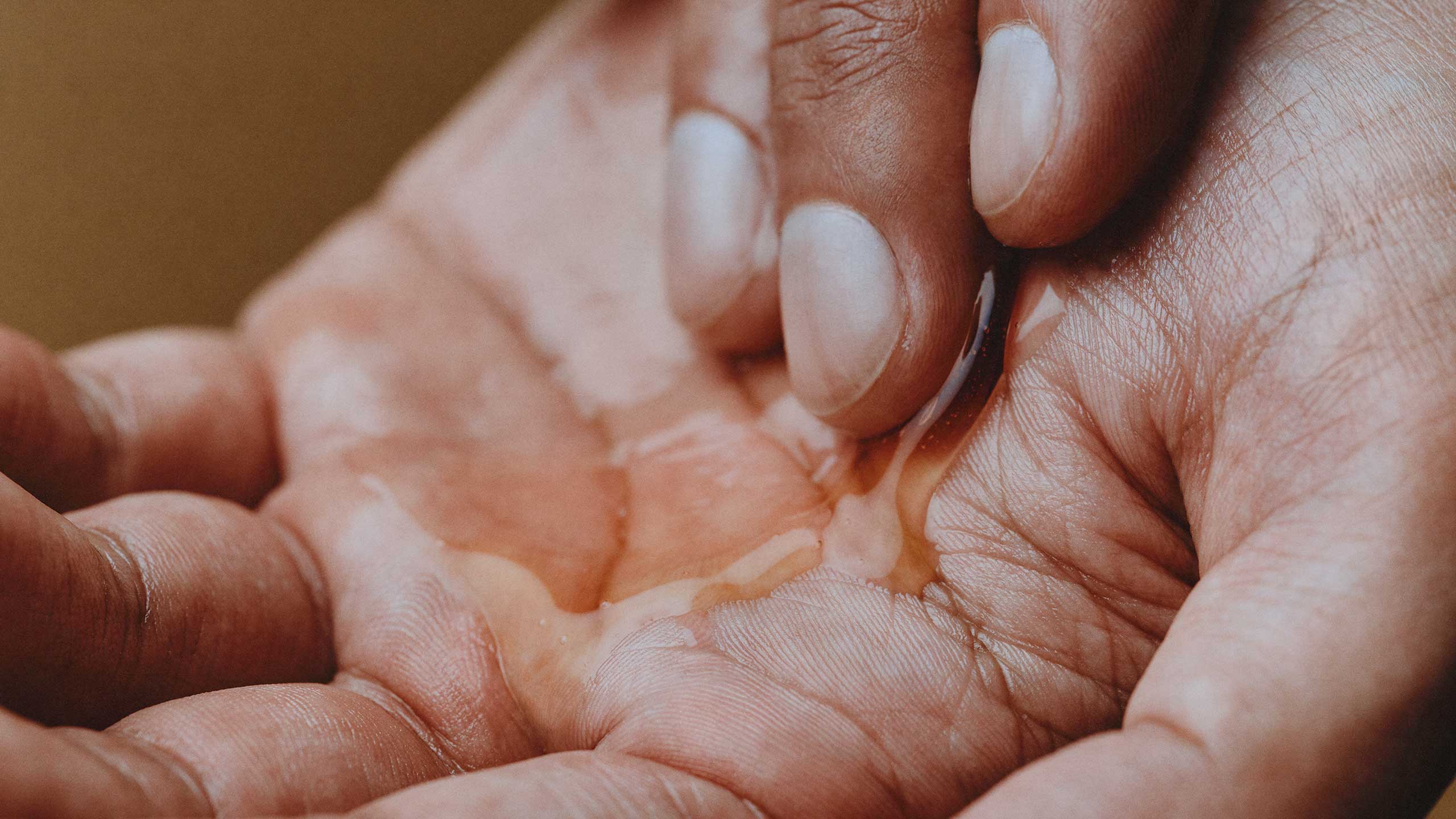 honey like skin product in palm of hand