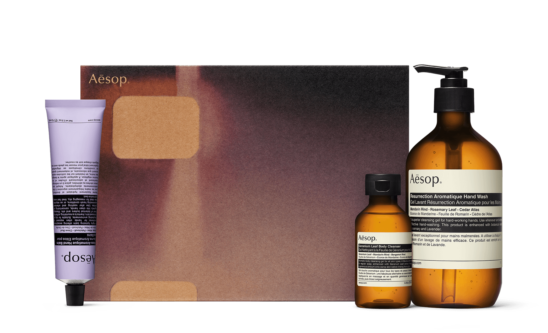 Three hand and body care formulations alongside a recycled cardboard gift box. 