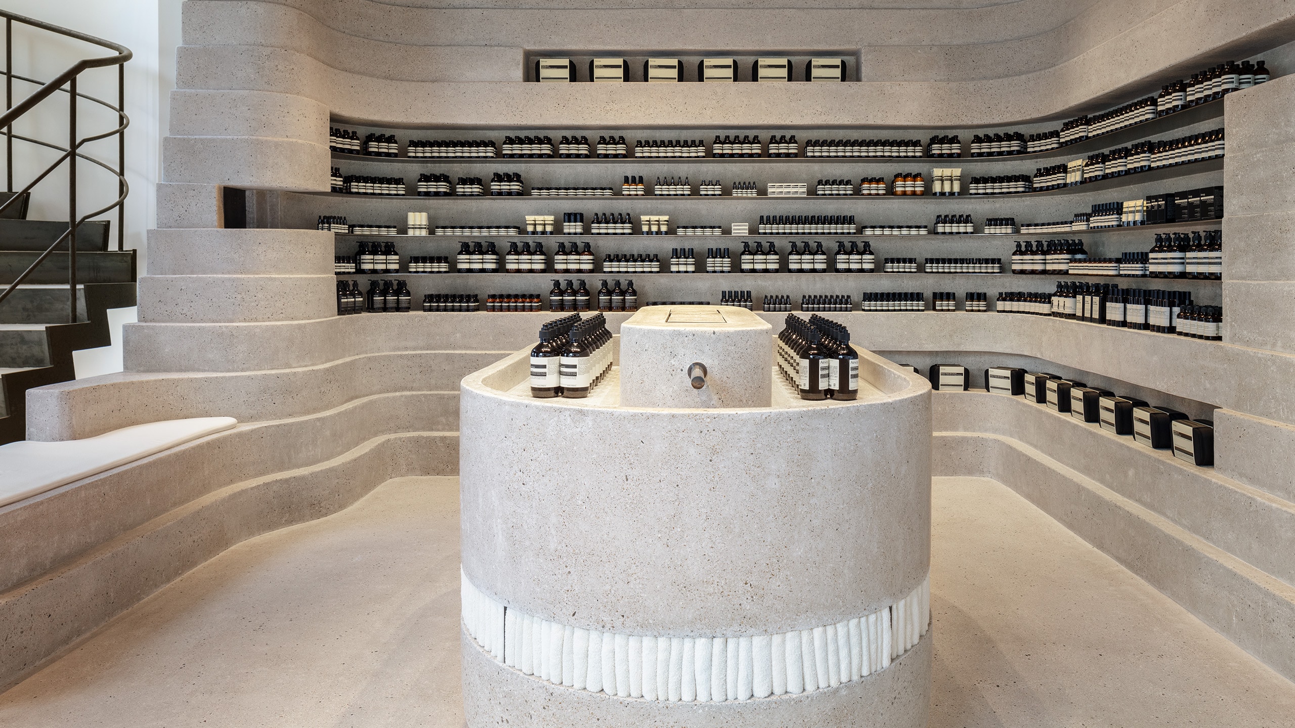 Curving concrete counters, walls, stairs and communal sink