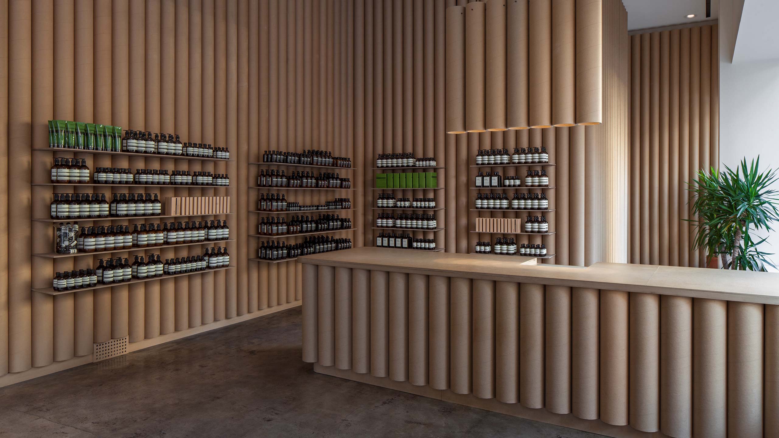 Shelves holding Aesop bottles fitted with cylinder cardboard