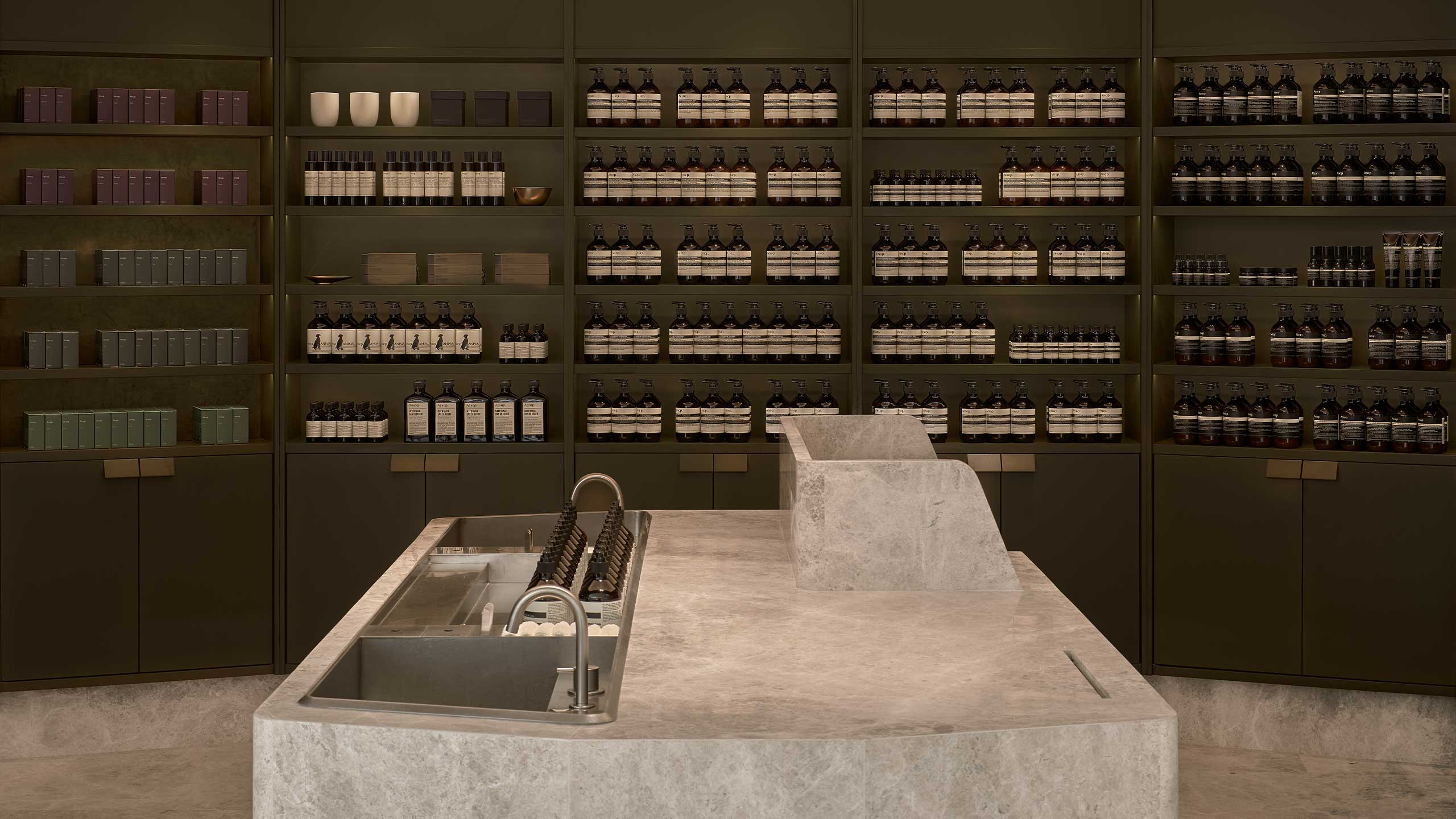 A monumental stone basin at the store with a full range of formulations for the Aesop skin, body, hair and home products at the back