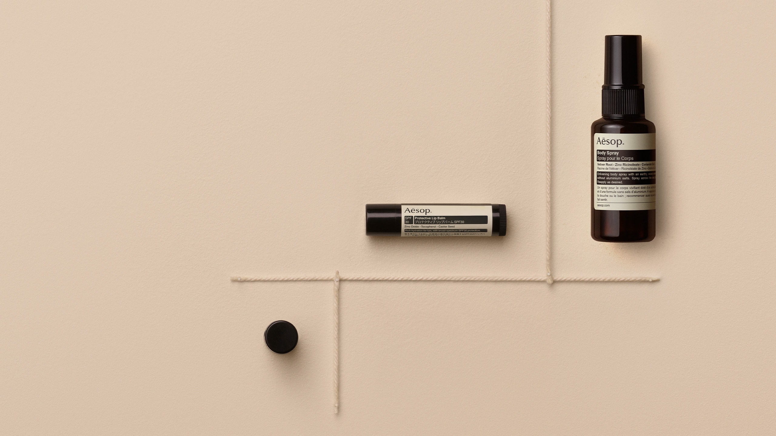 Body Spray and Protective Lip Balm on the beige background