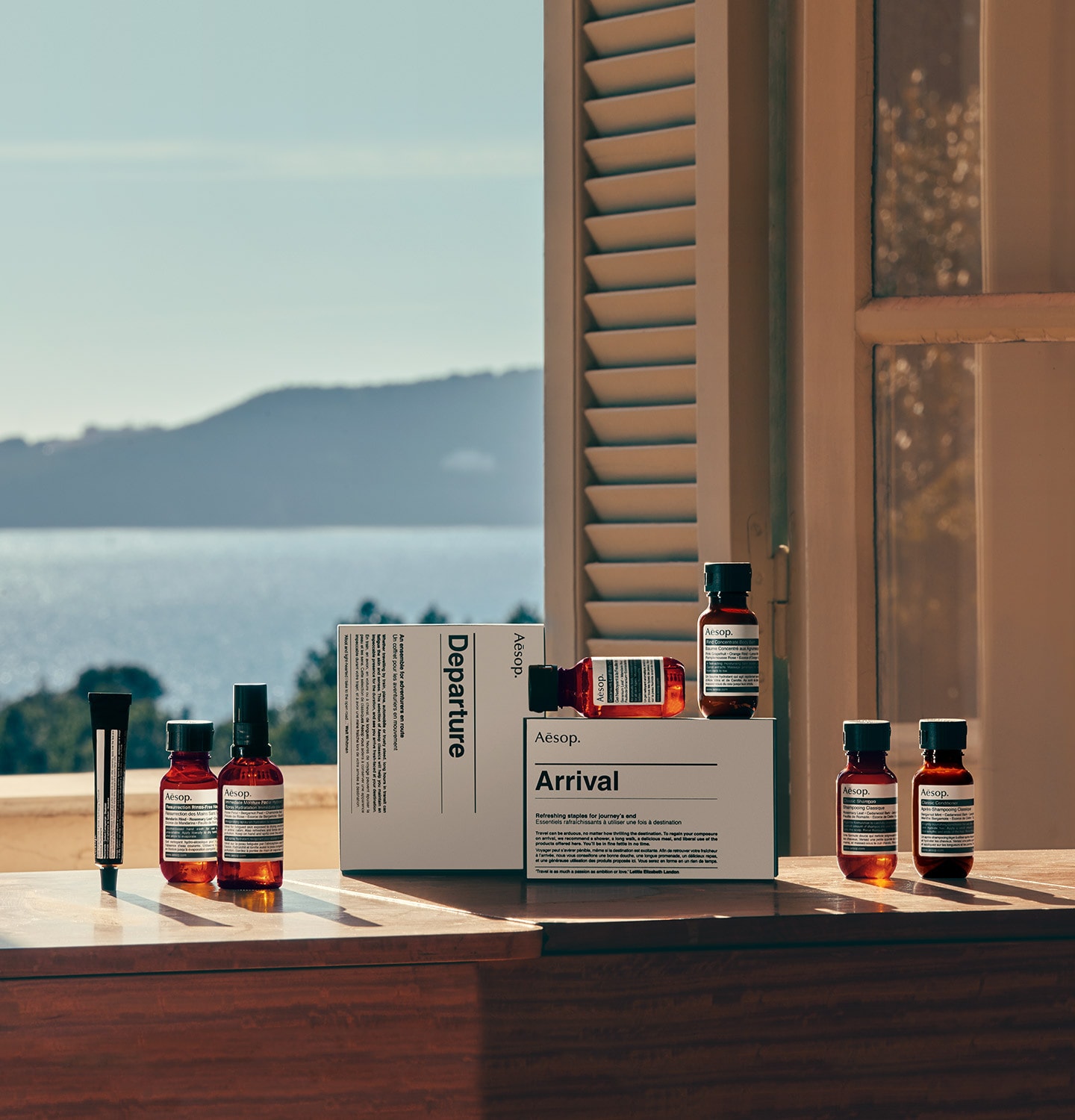 Arrival and Departure travel kits on a windowsill looking to the ocean