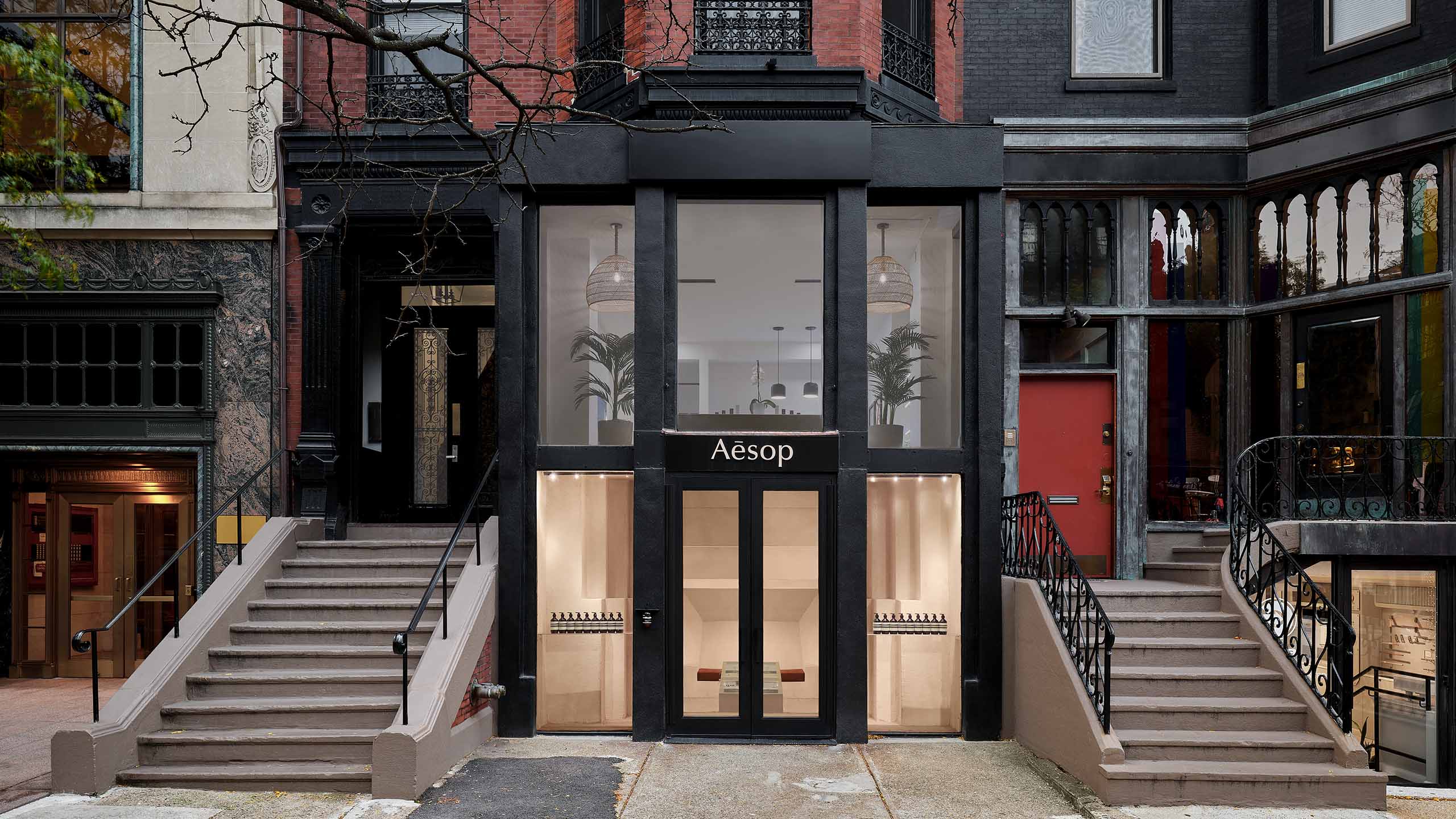 store front with black doors in between stair cases