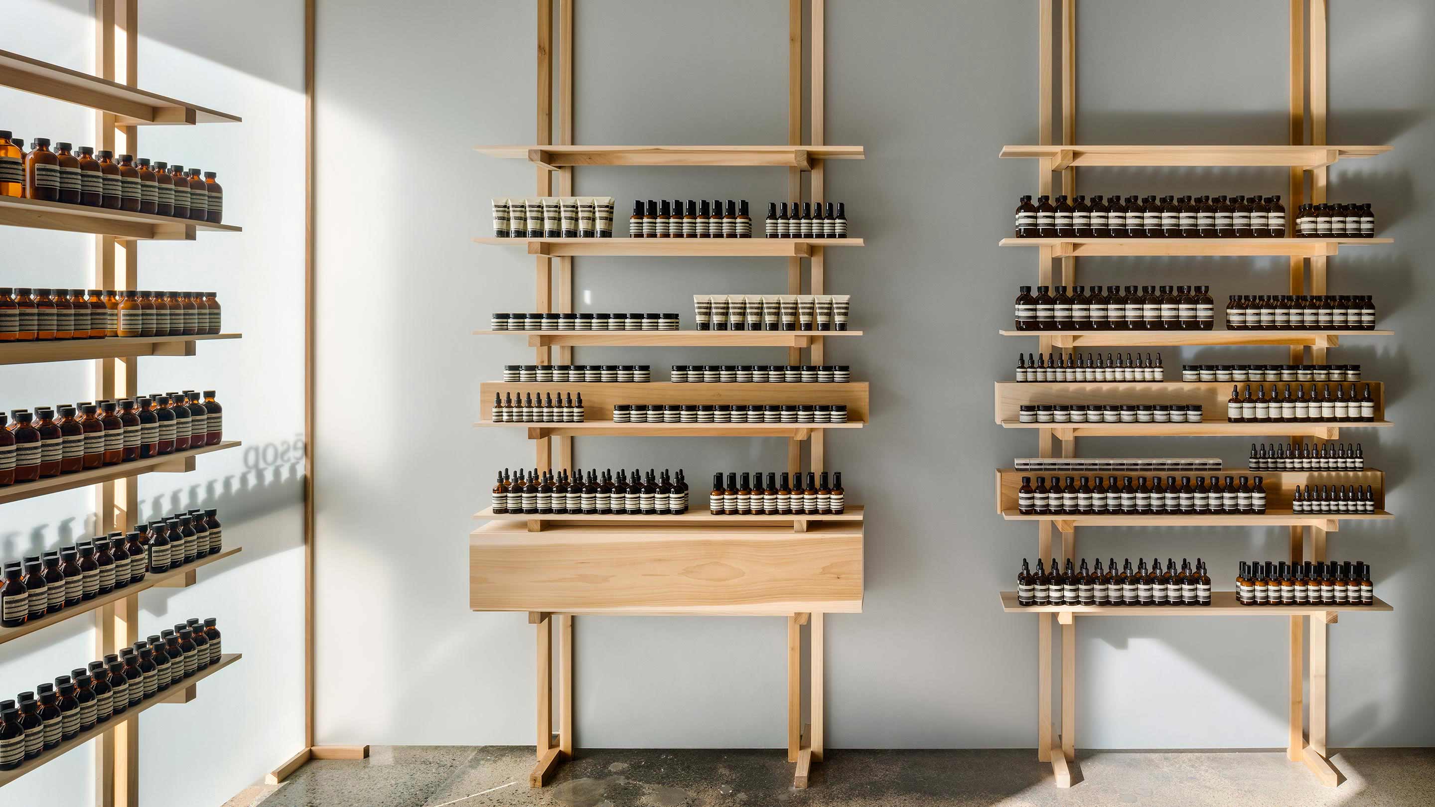 Wooden shelves with frosted panels hold the Aesop product range