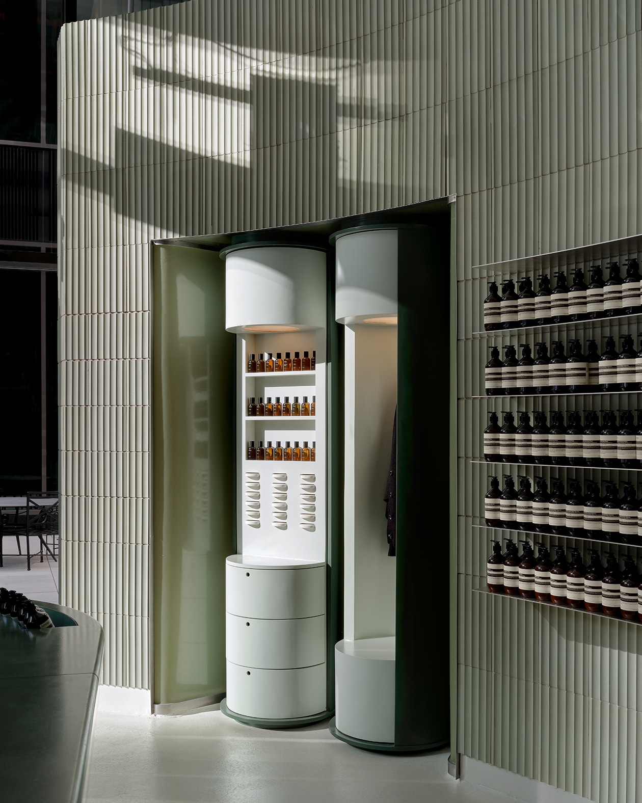 store interior featuring grey white corrugated walls, fragrance armoire and product on shelves