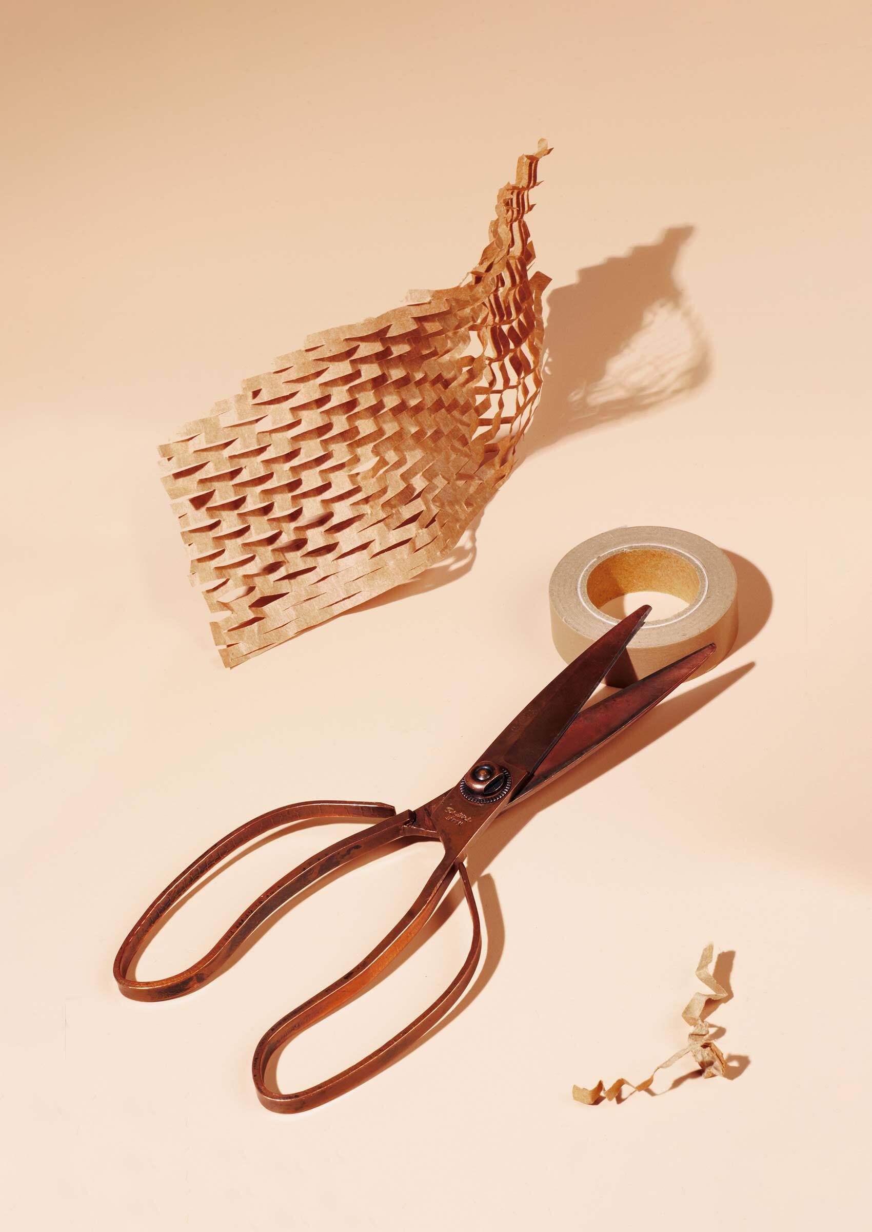 Scissors, tape and brown honeycomb packing paper.