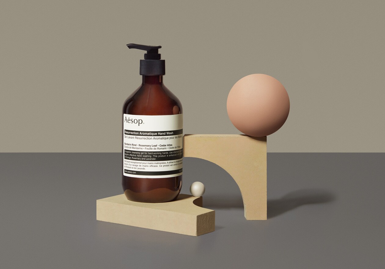 A 500ml pump bottle of Resurrection Aromatique Hand Wash sitting next geometric figures.