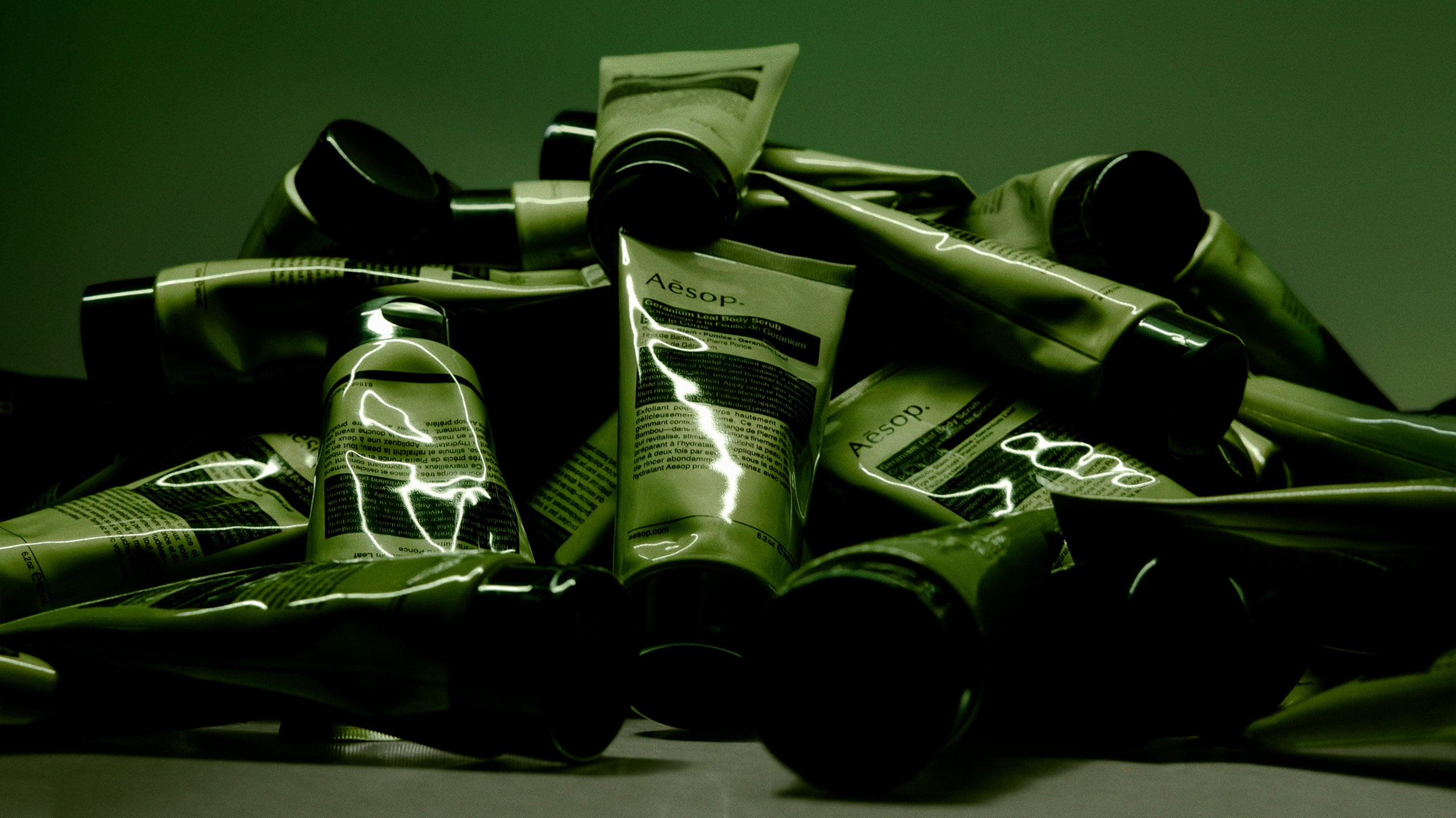 A pile of Geranium Leaf Body Scrub scattered against a green background.