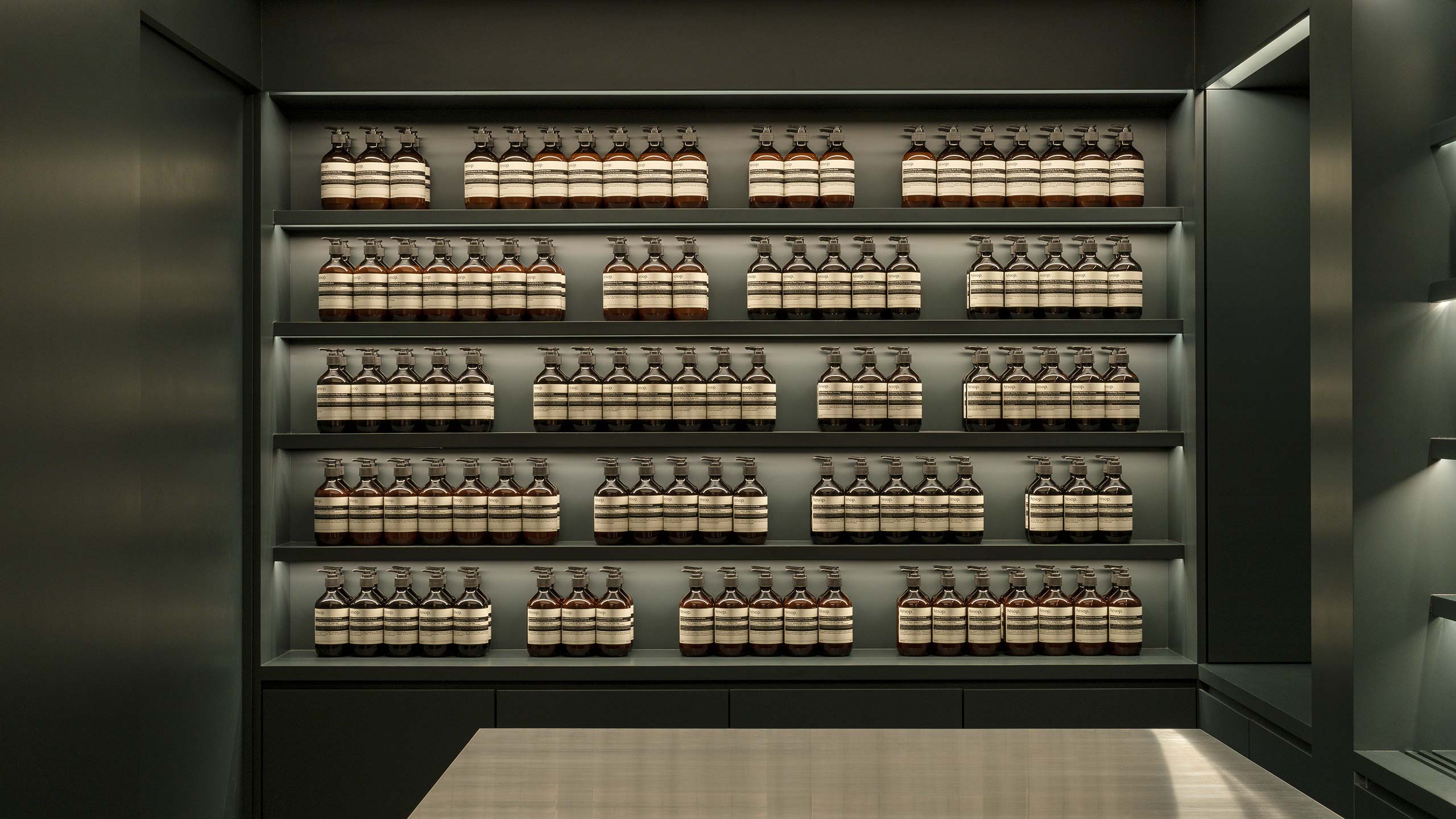 Recycled wooden shelves on the walls showcasing Aesop products