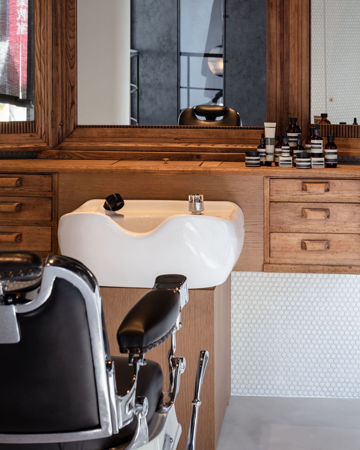 An interior design of a hair salon with a shampoo bowl and a vintage barber’s chair