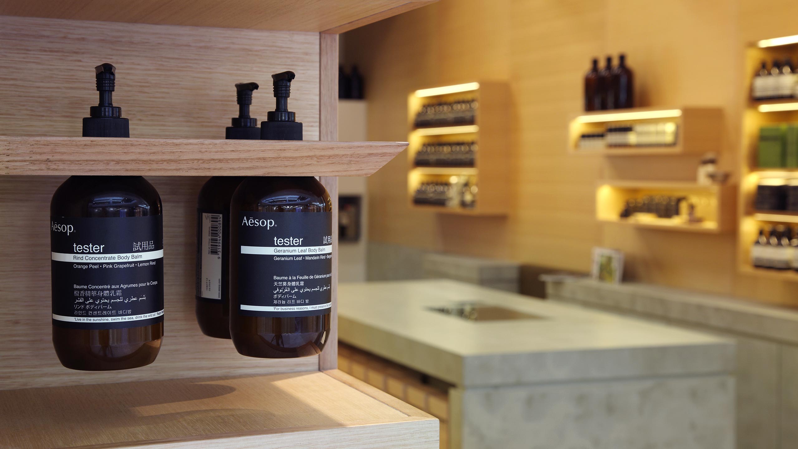 A close-up of Aesop tester bottles of 'Rind Concentrate Body Balm'