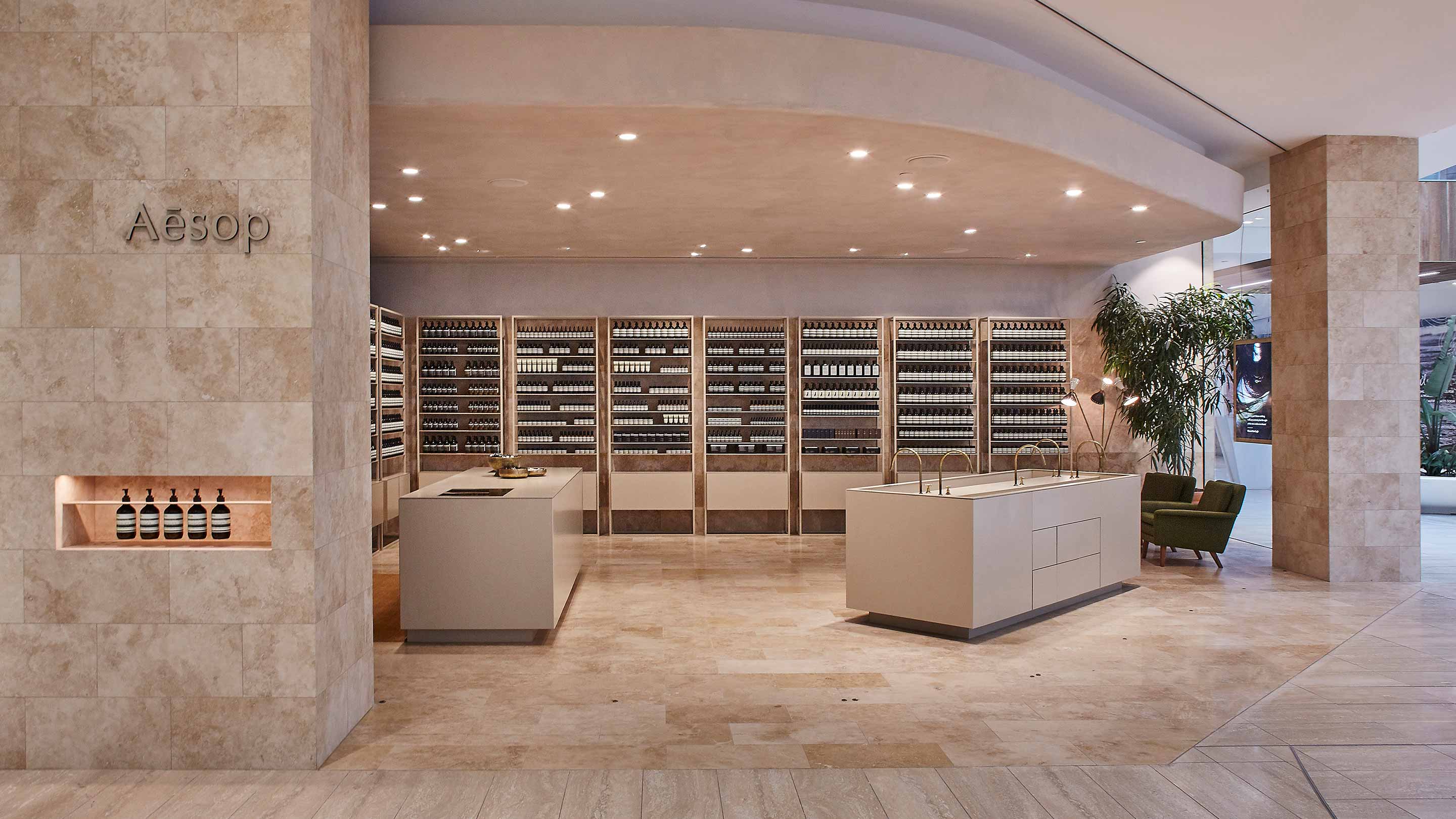 Marble Aesop store interior showing a counter, basin and shelving,