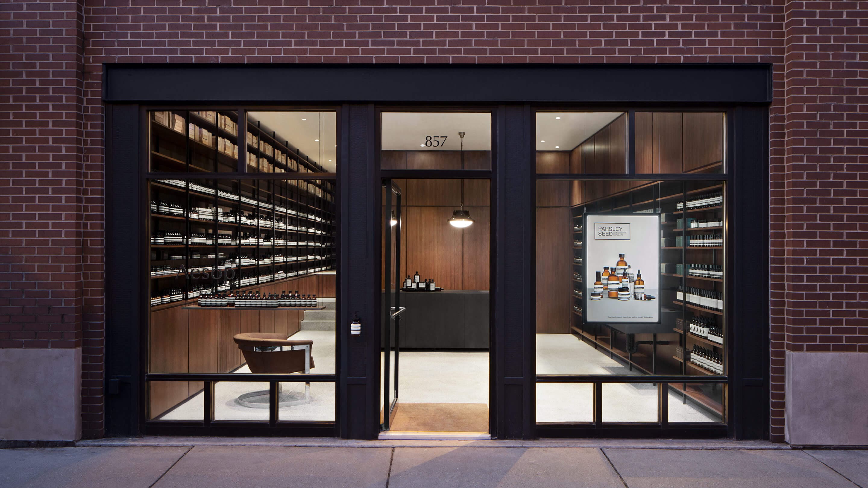 A brick store entrance with black framed glass windows