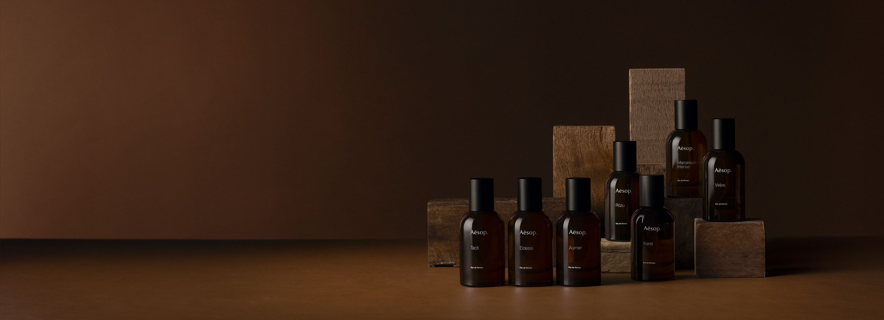 Aesop fragrance in amber glass placed on a textured surface