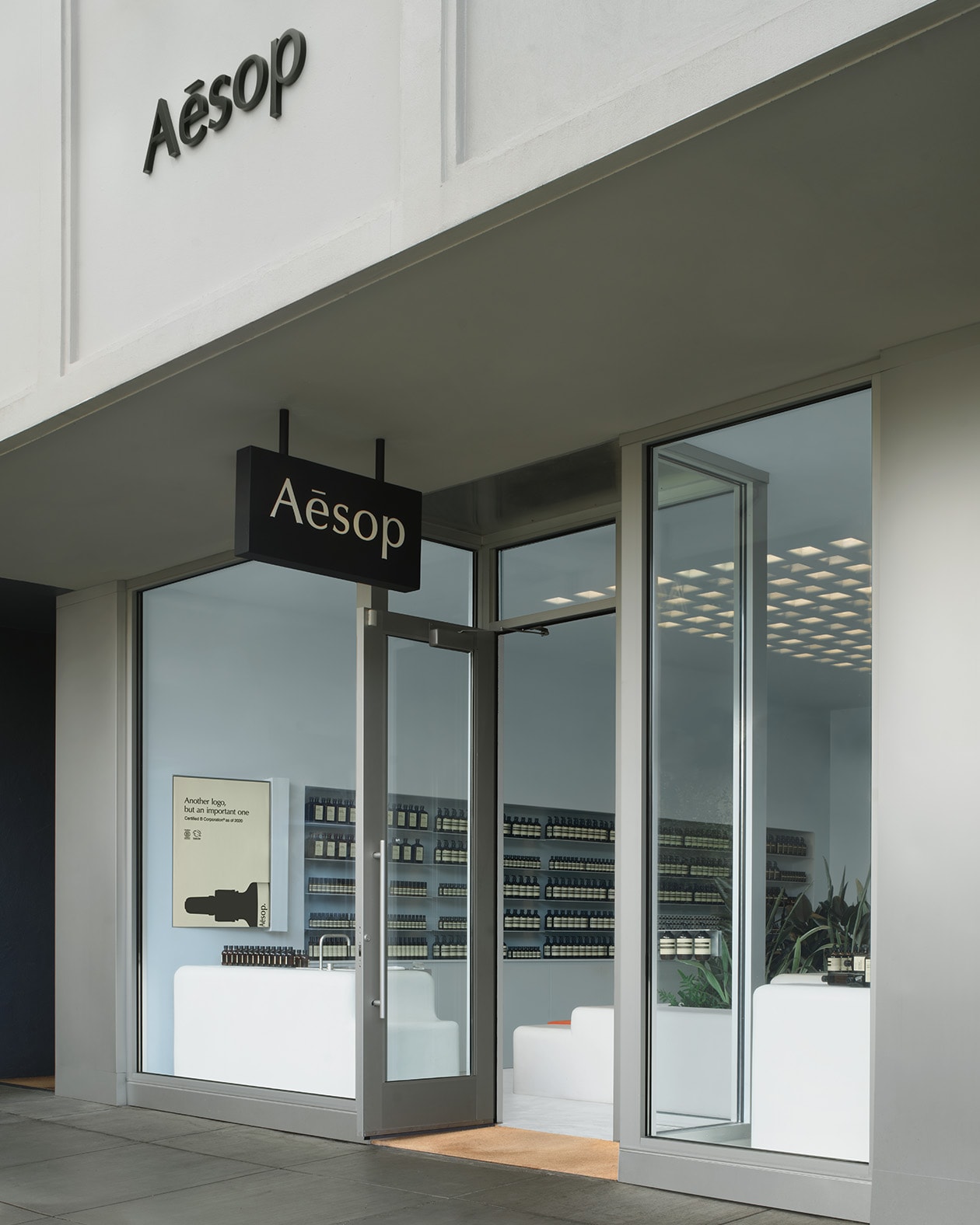 store exterior shot of grey facade with glass walls looking into grey-blue store interior