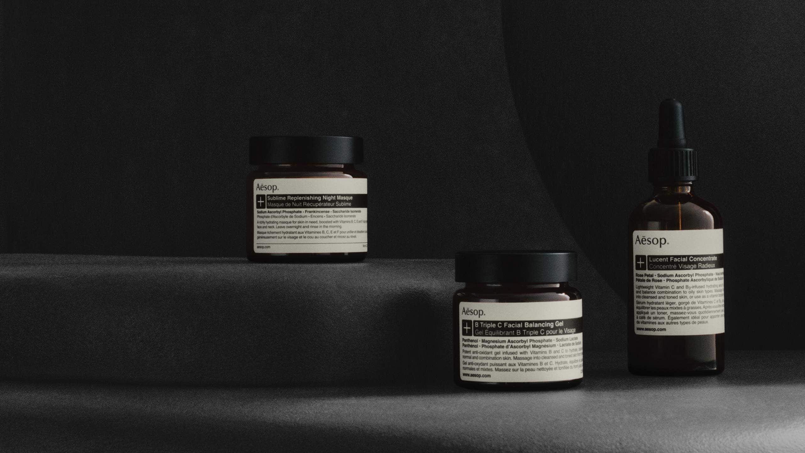 Line up of products on a greyscale set, featuring Sublime Replenishing Night Masque, B Triple C Facial Balancing Gel and Lucent Facial Concentrate