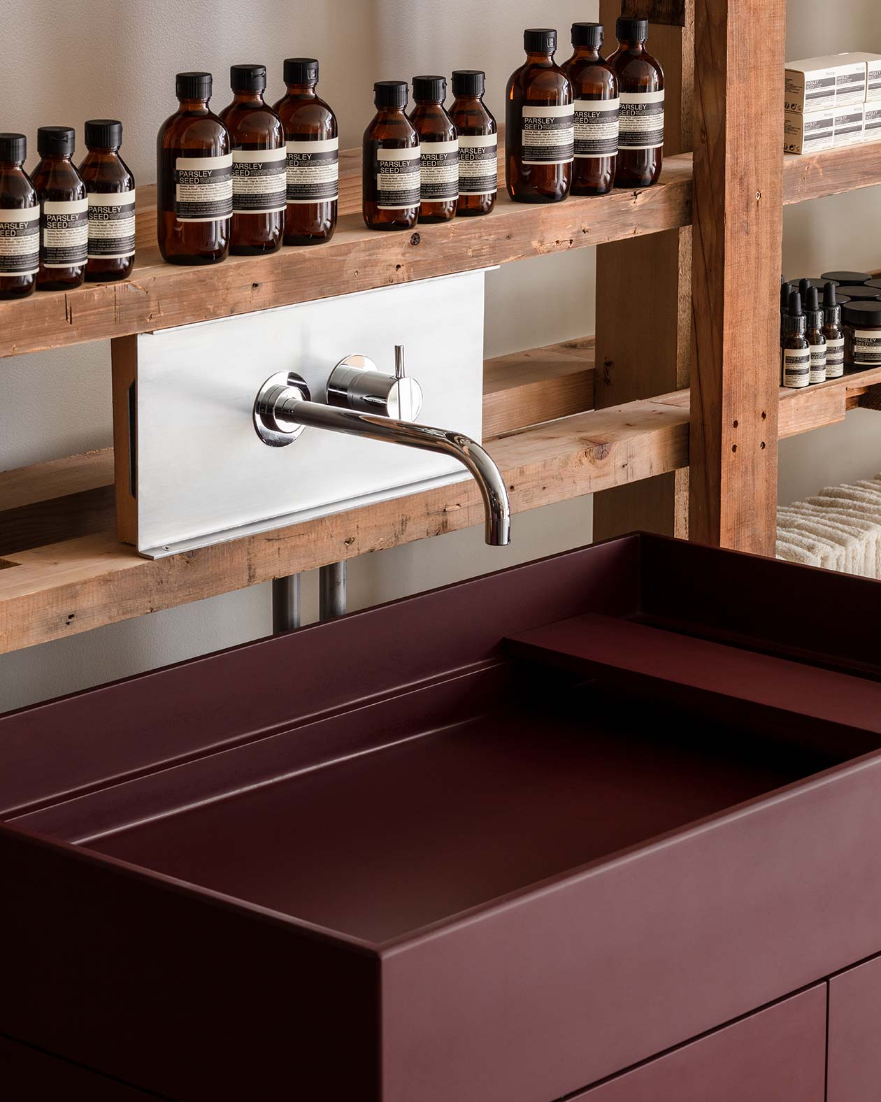 A red urushi (lacquer) basin under a shelve of Parsley Seed Skin Care products