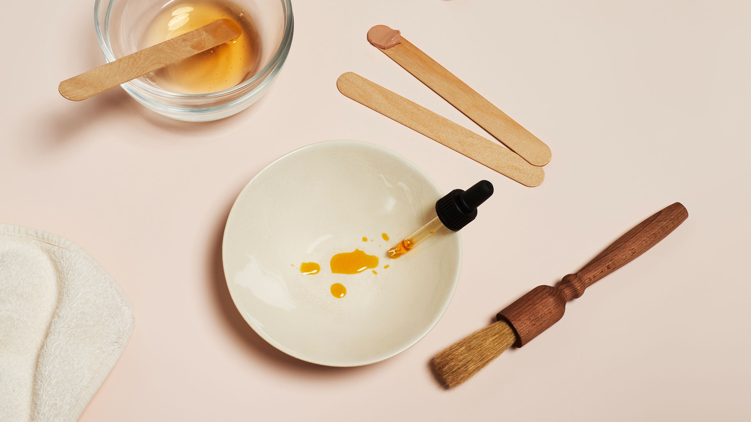 A dropper with face oil in a bowl