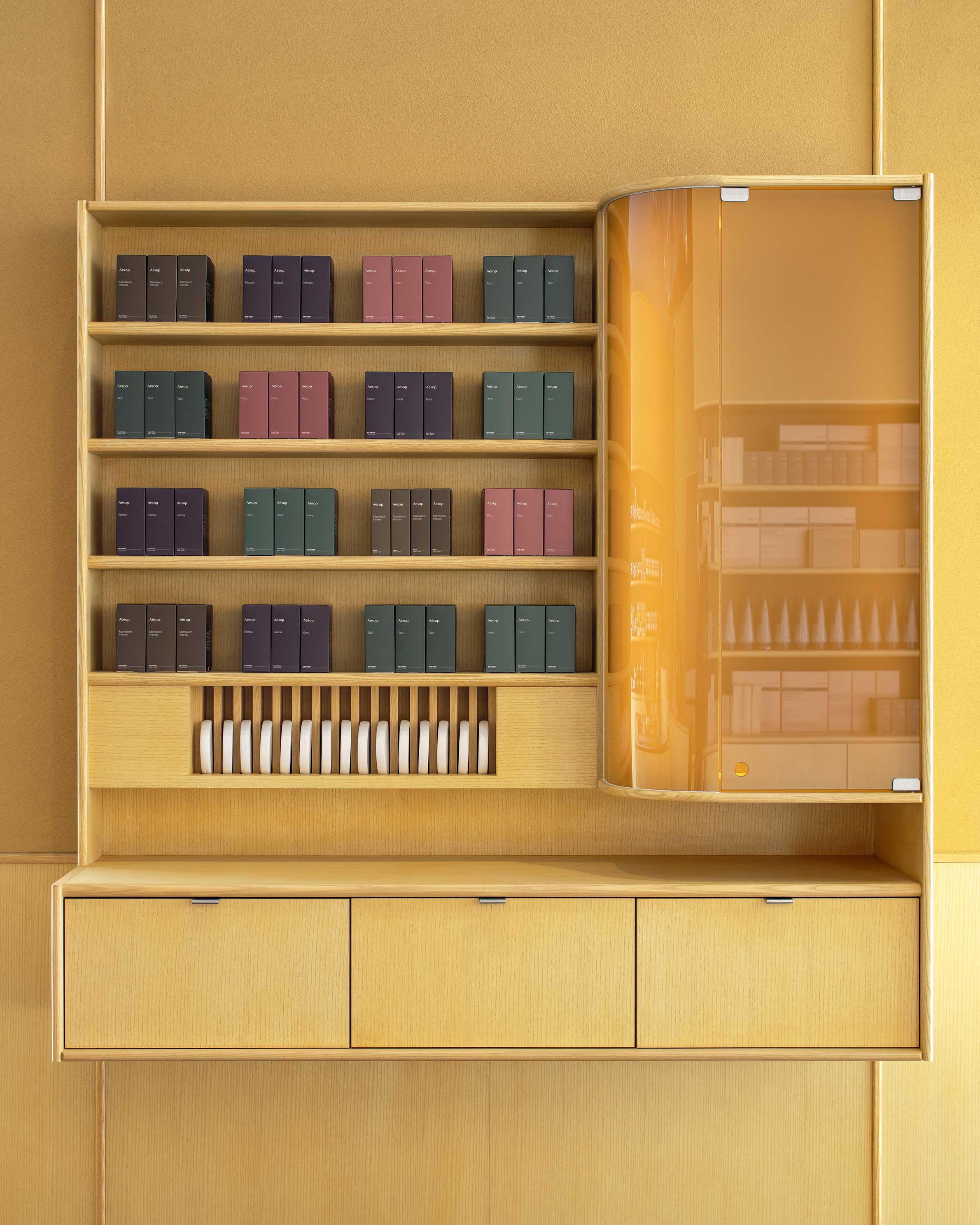 Yellow wooden cabinet displaying Aesop fragrances