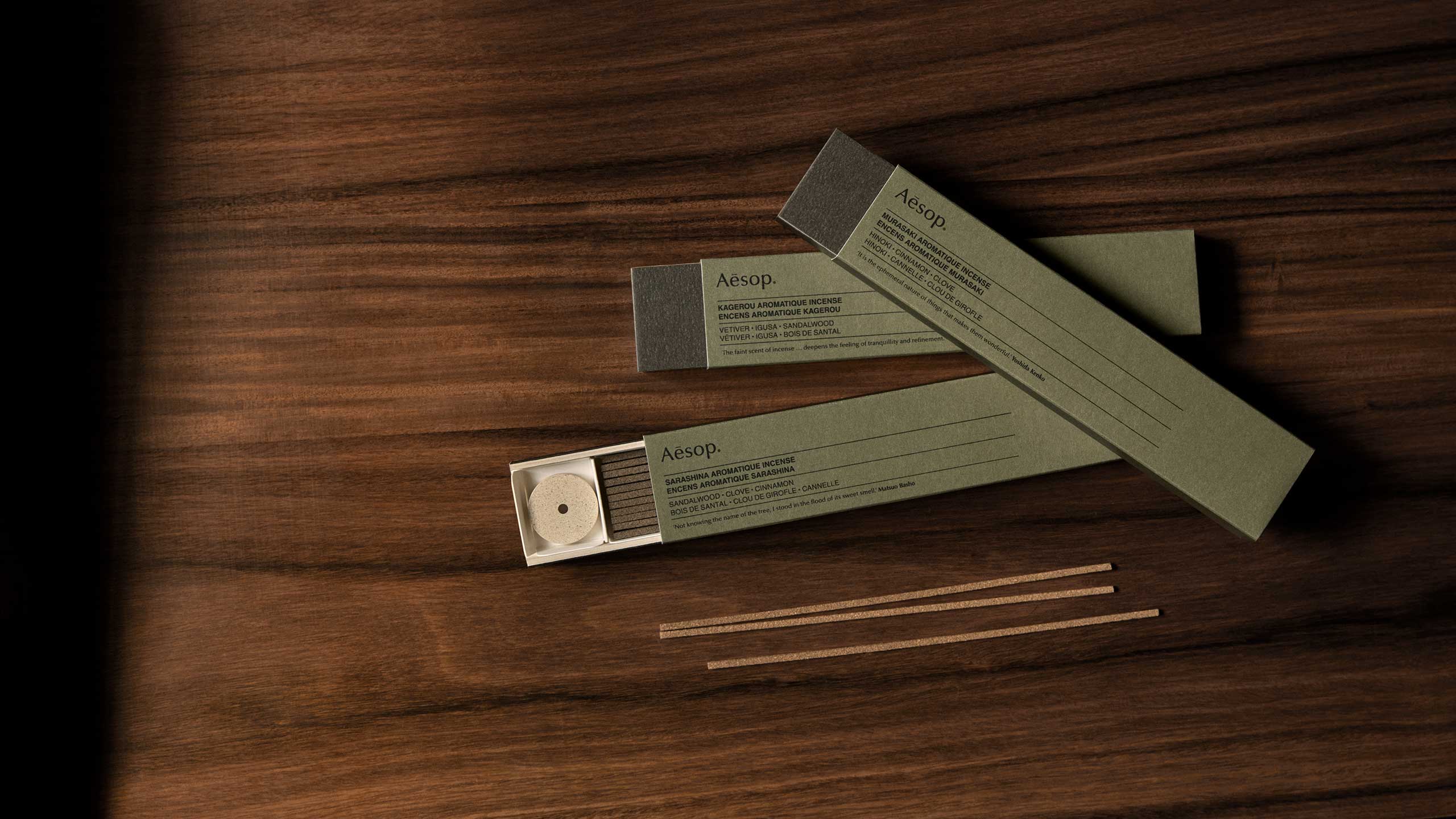 Three cartons of incense resting on a wooden surface.