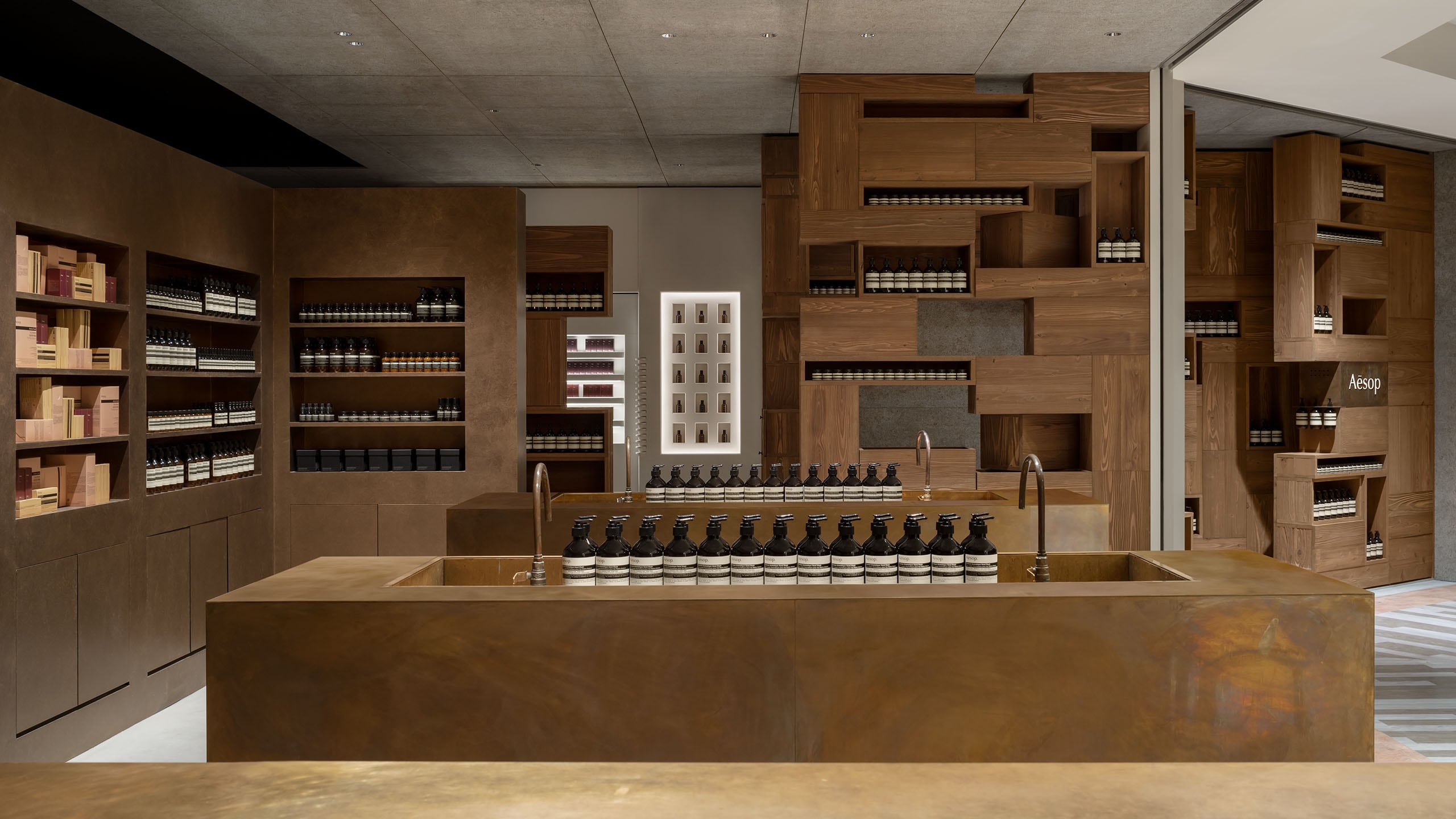 Aesop Hakata AMU plaza store overview, focused on the basin and  stacked timber boxes create an intimate space