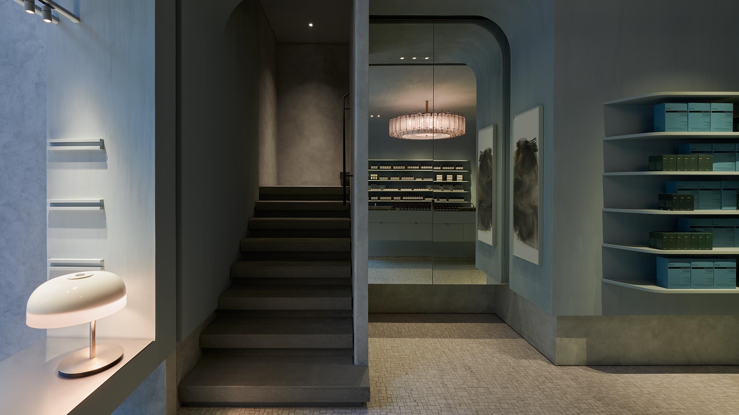 The pale blue of the mosaic washes over the vaulted ceiling, whose boundaries with the walls and staircase are blurred by fluid lines