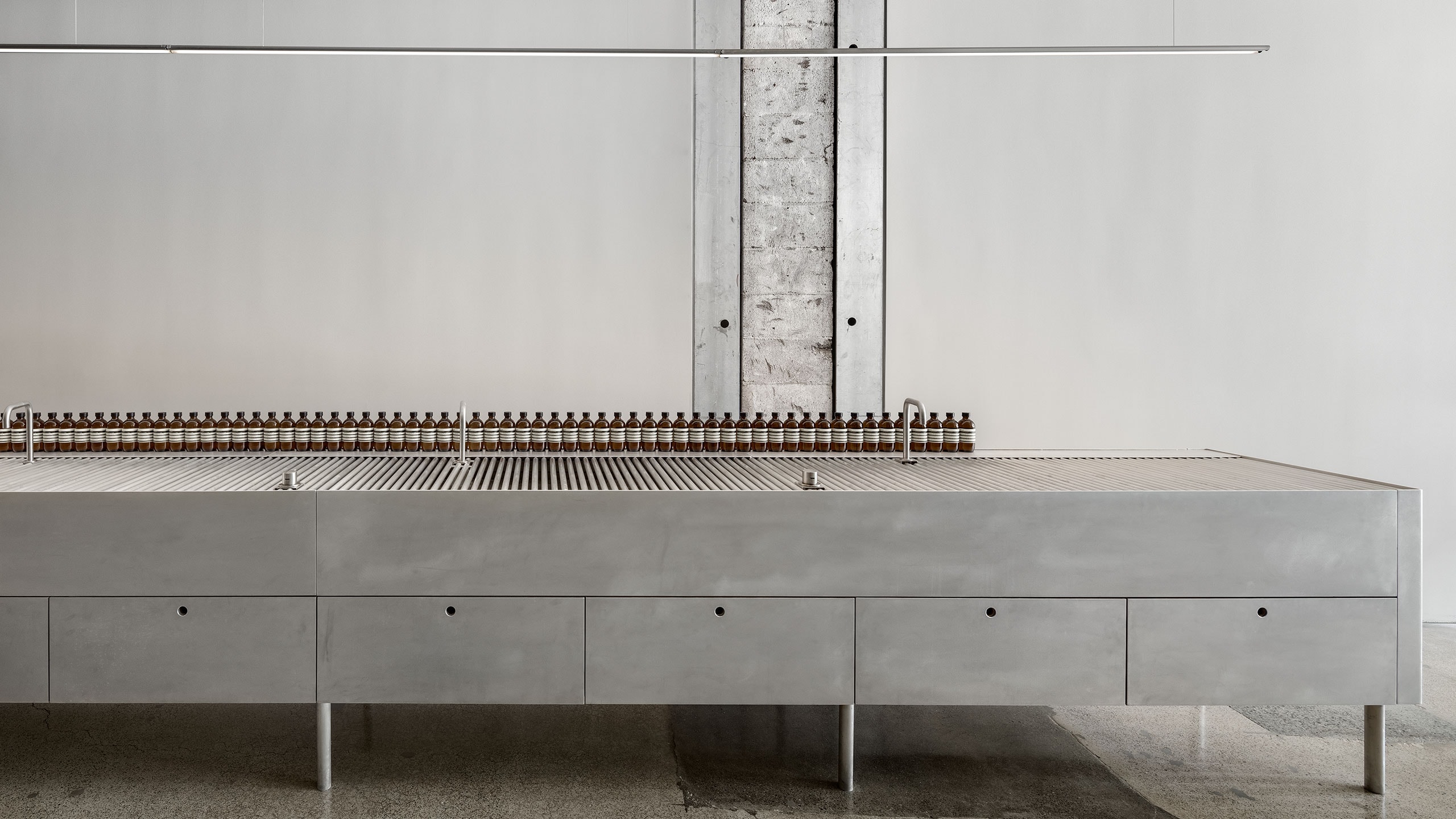 Steel sink with tester products arranged in a row along the sink.