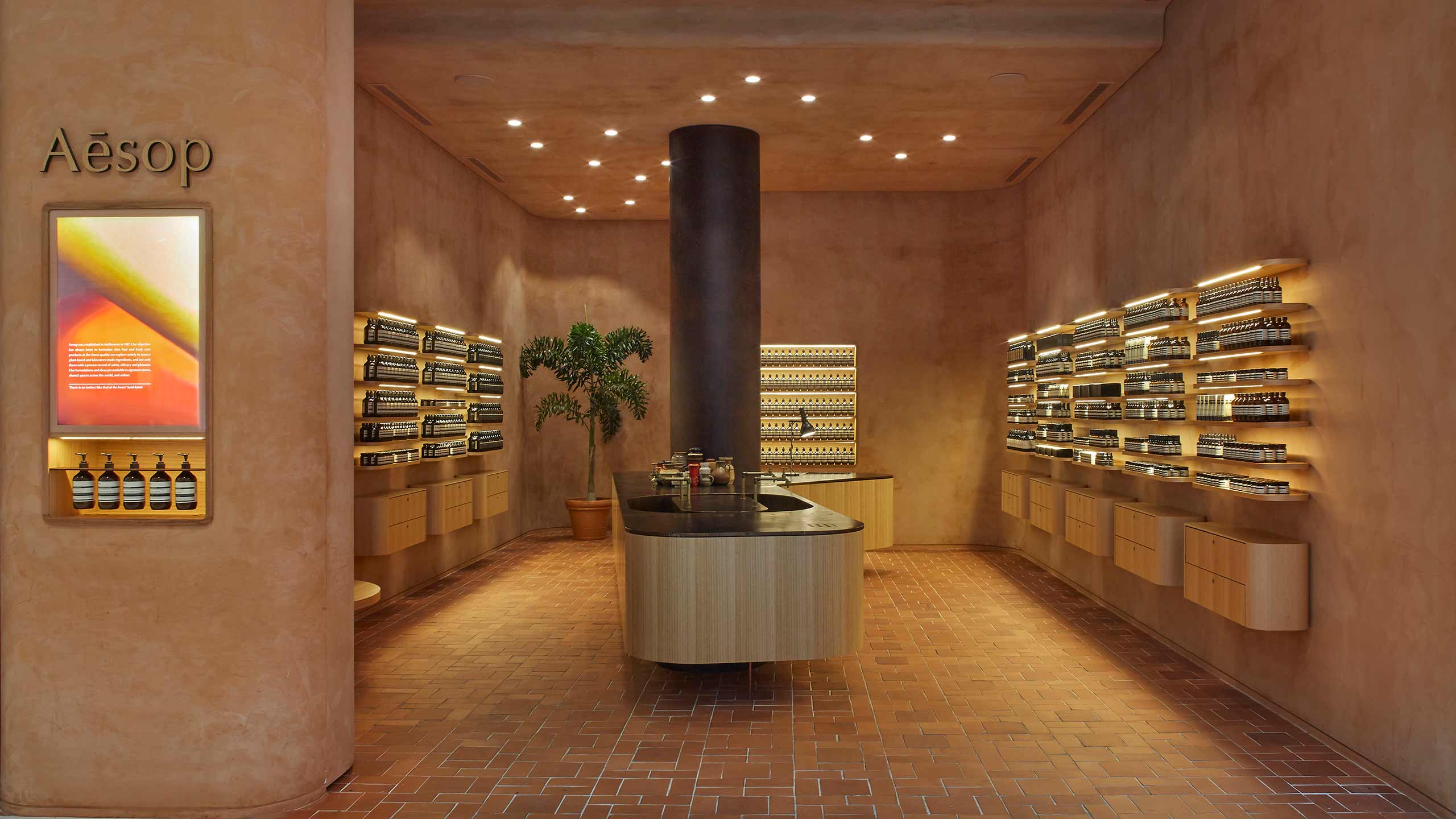 A wide-angled shot of store that shows the burnt-orange interior of the walls and the unconventional down-light arrangement on the ceiling.