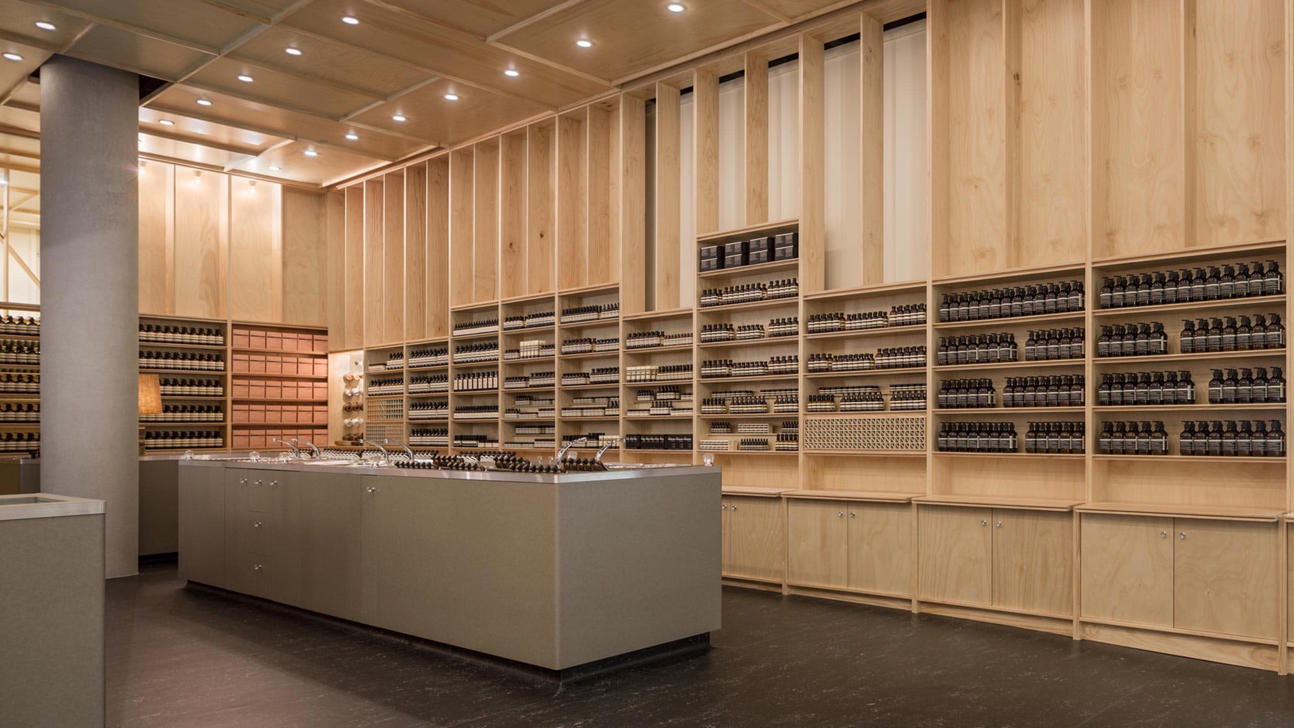 A smooth, grey customer service counter. The walls are made of natural timber, and the Laminex flooring gives the store a warehouse feel. 