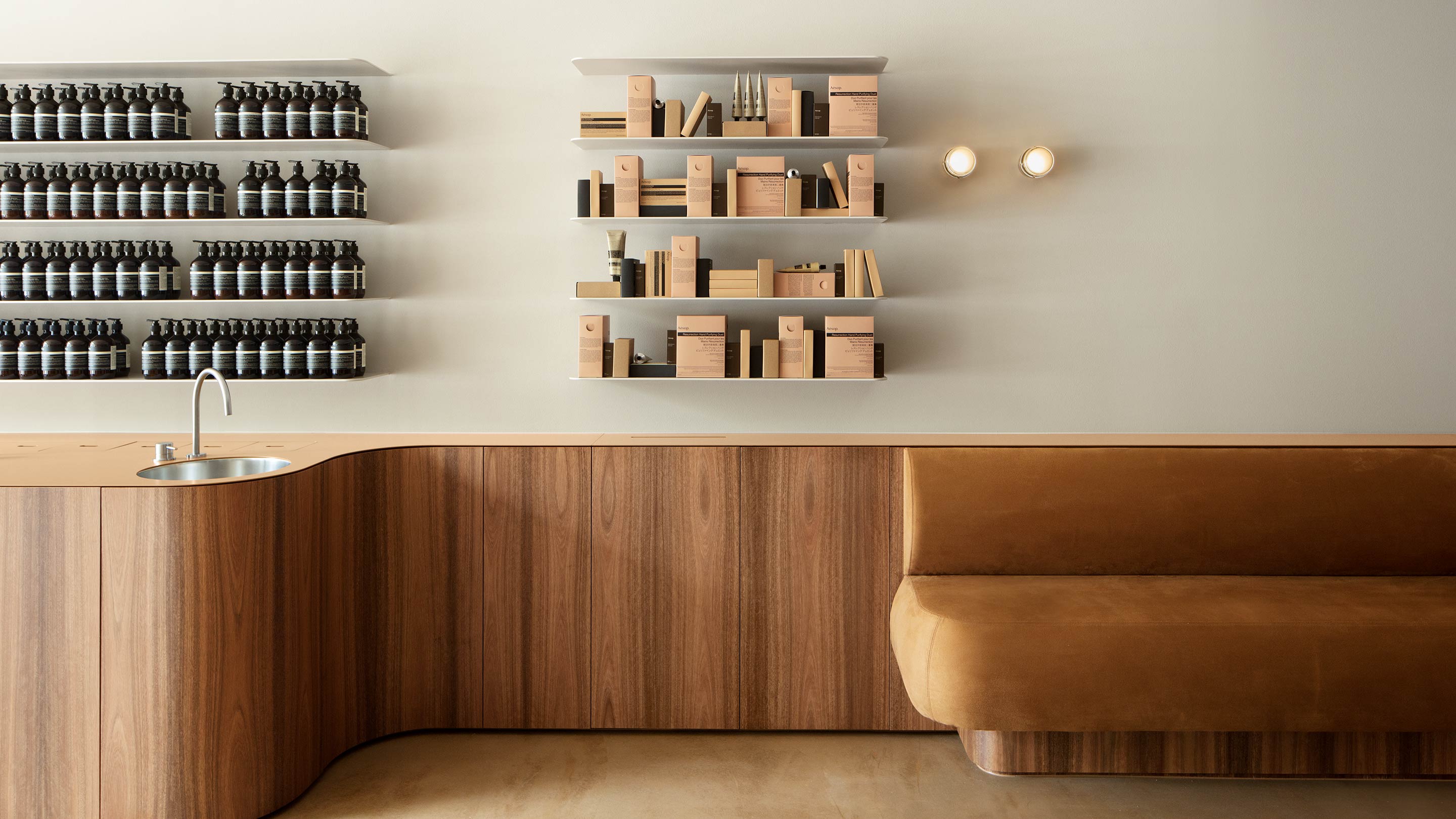 Wooden service desk with Aesop products on display behind