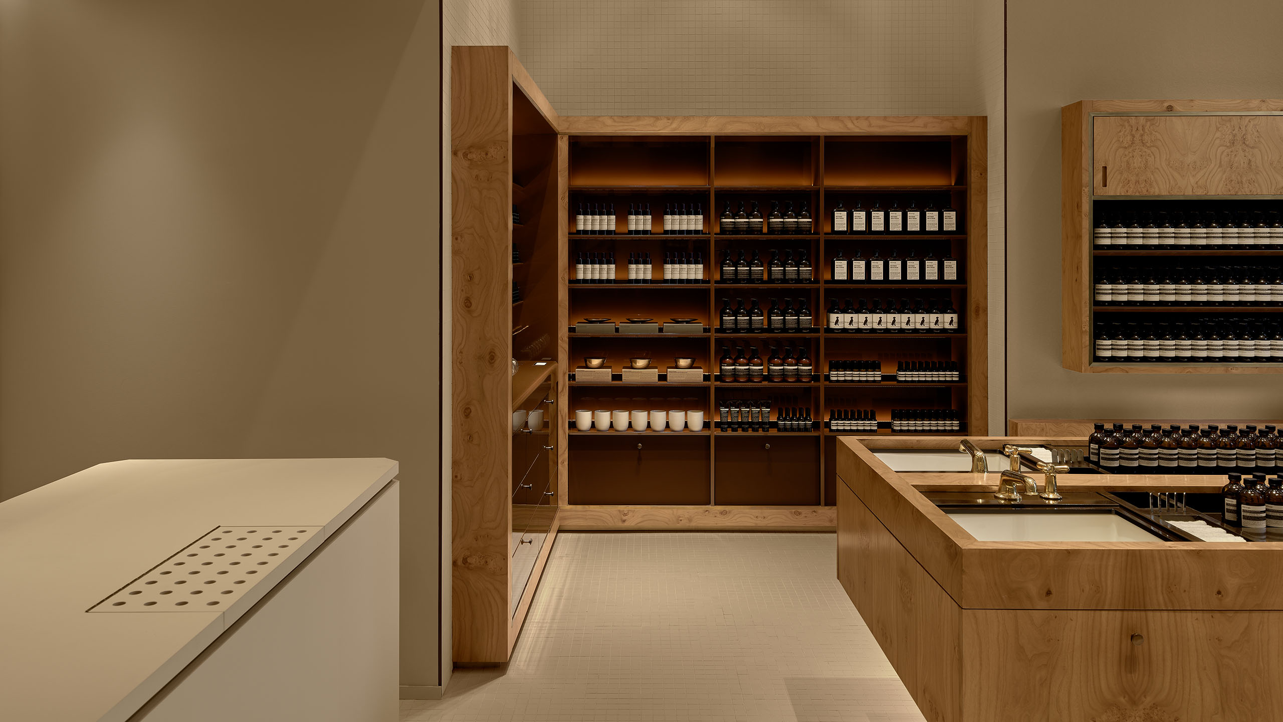 store interior with cream checkout counter to the left, wooden basin unit to the right, and wooden product shelving unit ahead