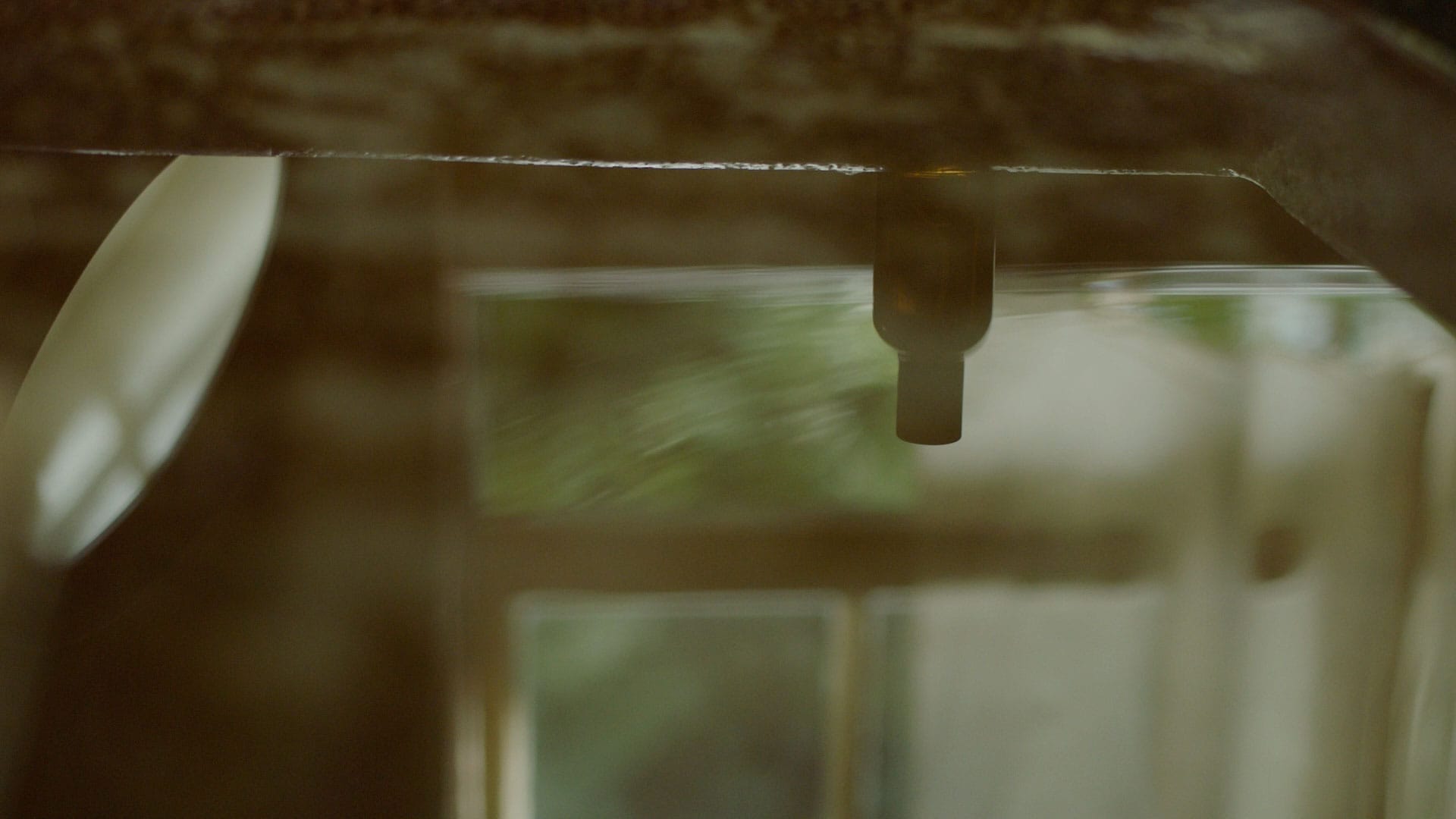 A reflection of an Eidesis Eau de Parfum bottle in a pool of rippling water.