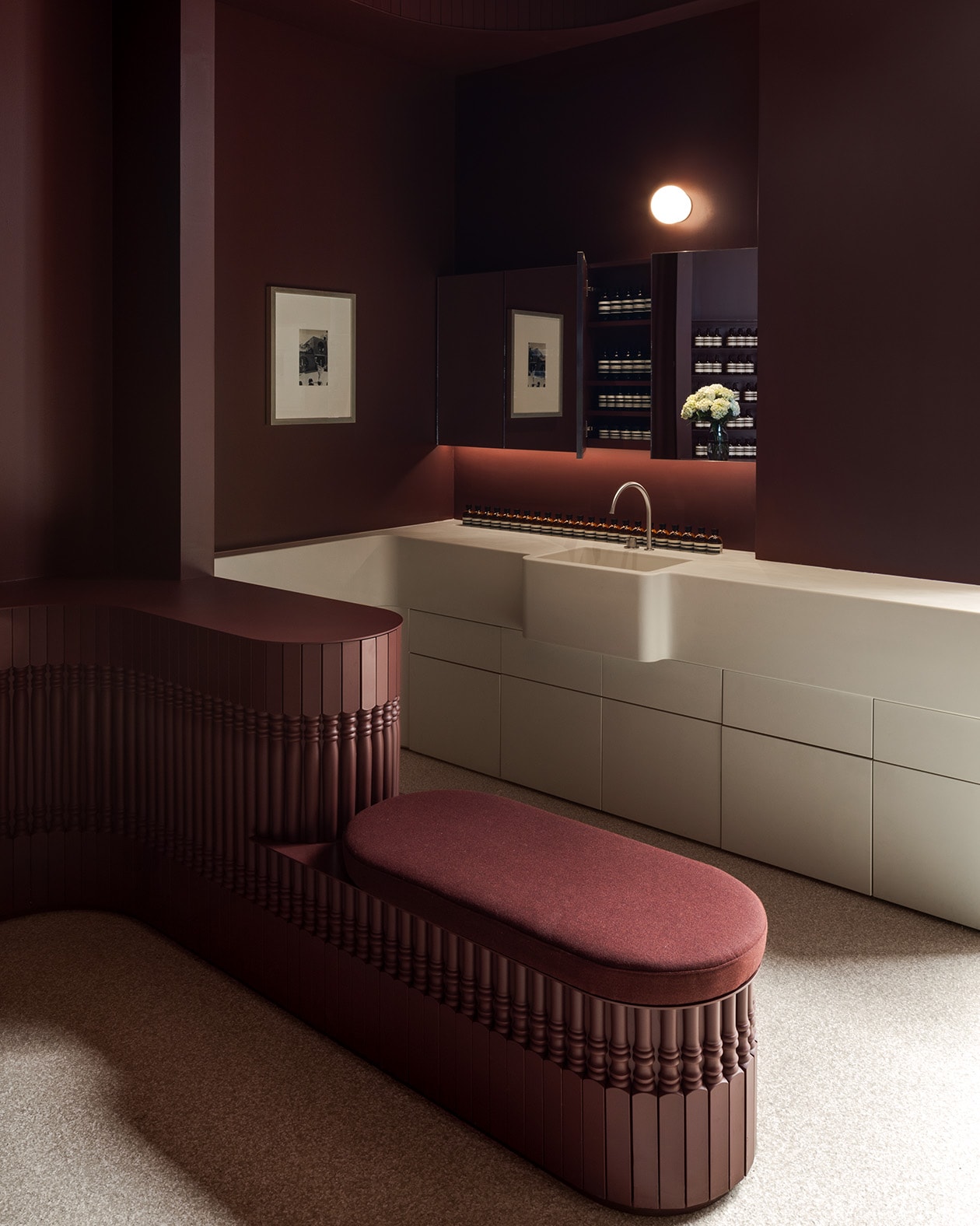 Deep, rich plum-colored seating surrounds a large white sink.