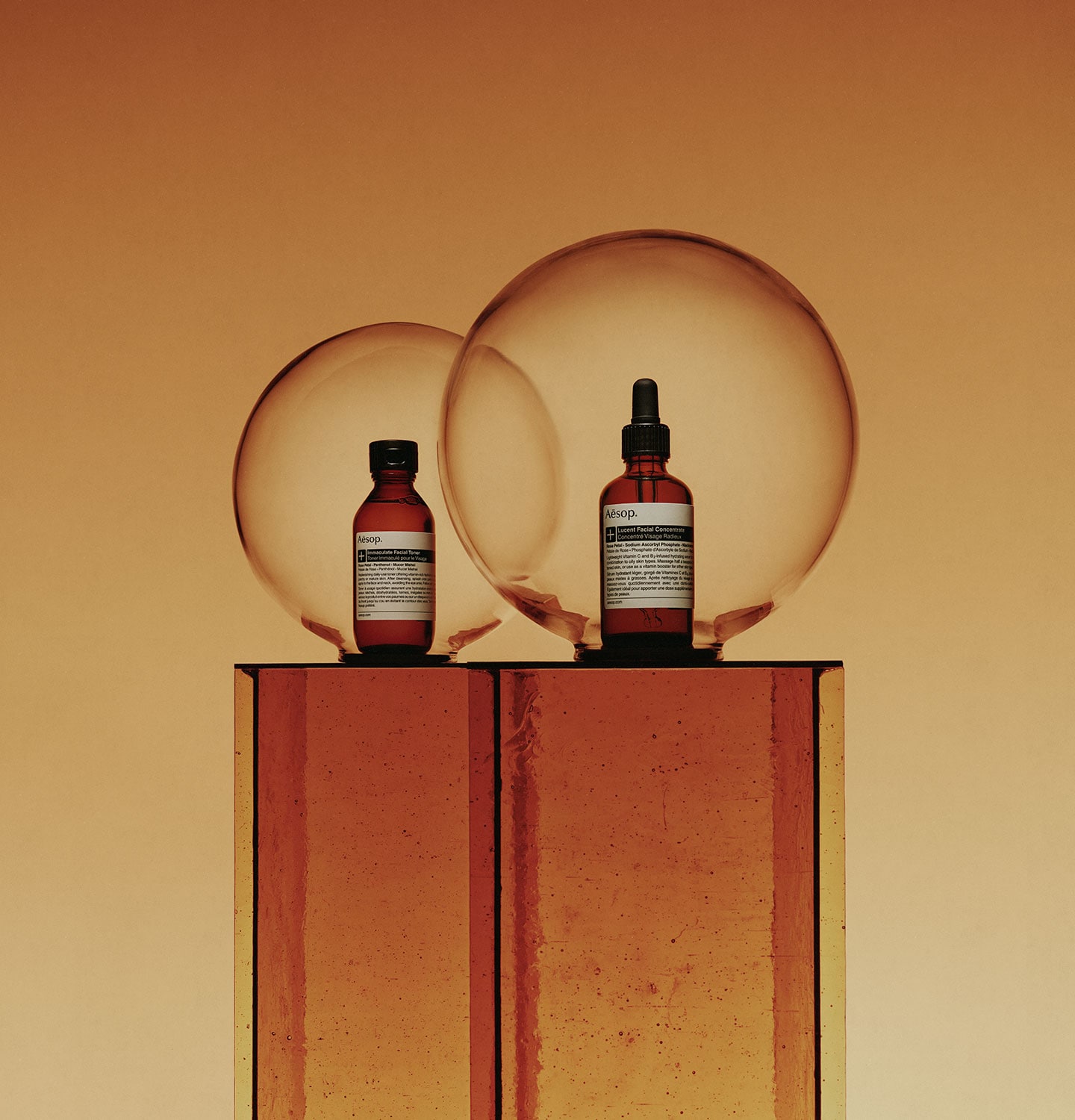 Immaculate facial toner and lucent facial concentrate placed in front of amber background
