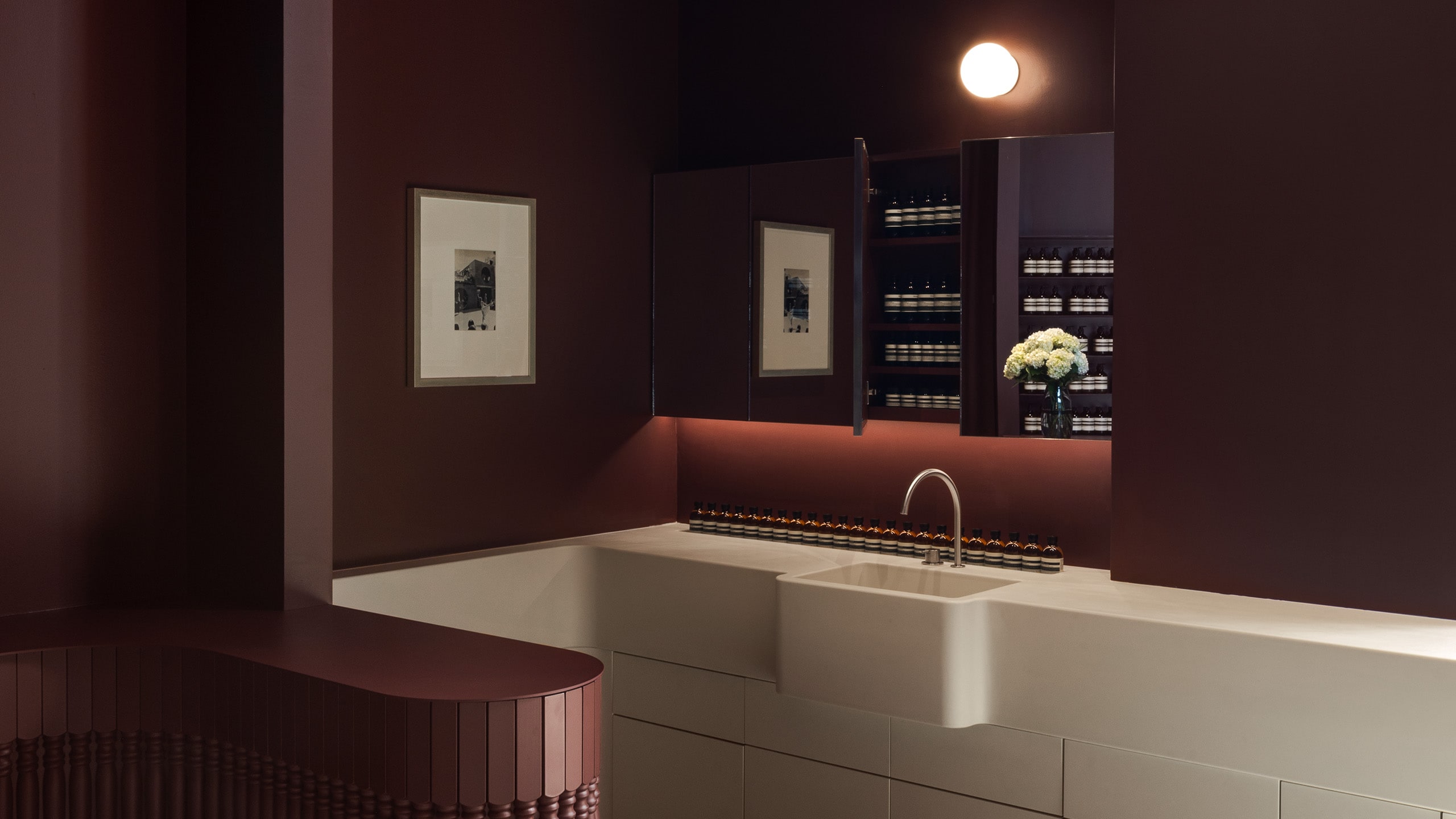 Deep, rich plum-colored seating surrounds a large white sink.
