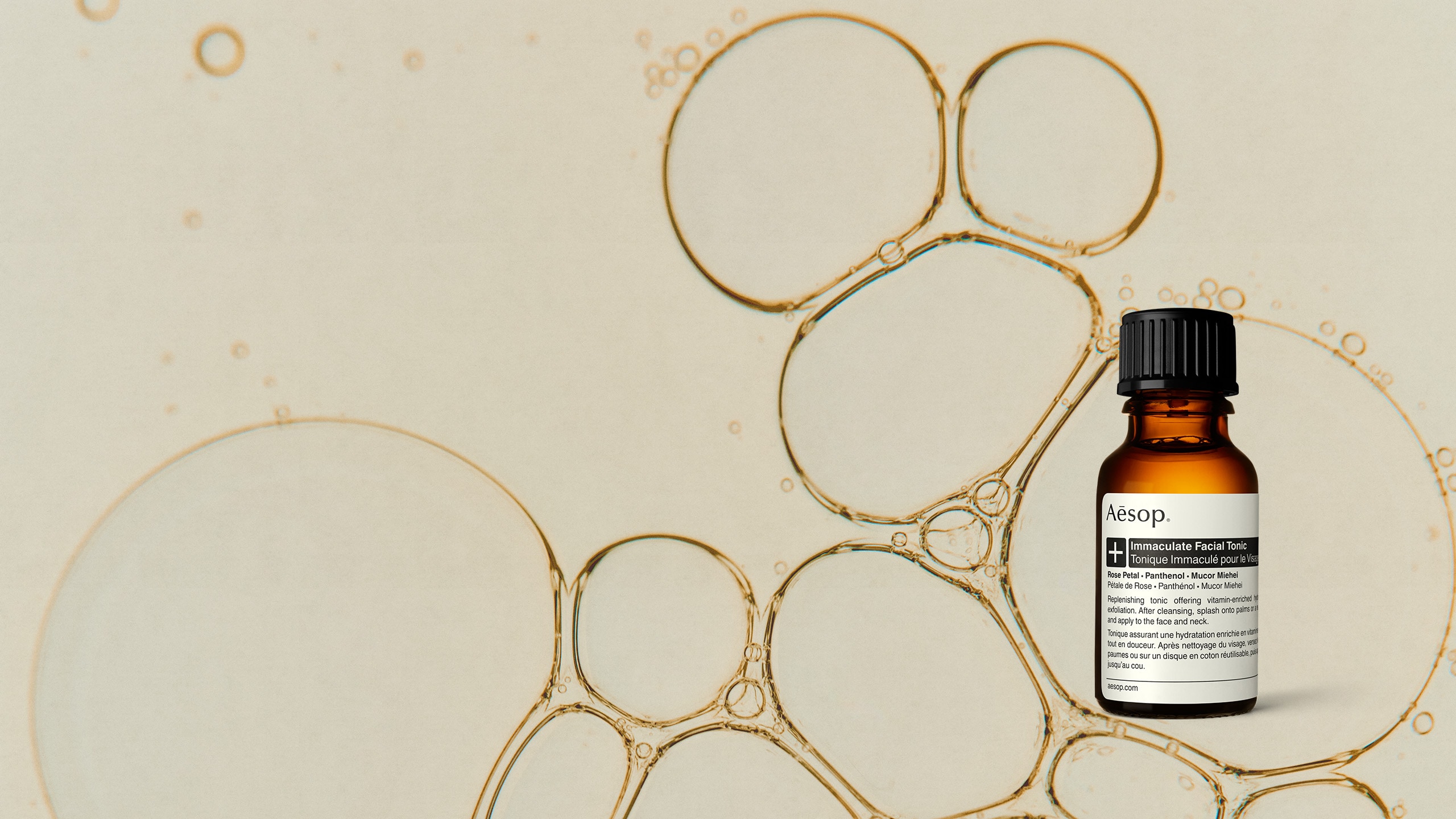 A sample of Immaculate Facial Toner on an abstract close-up background of liquid droplets of various sizes
