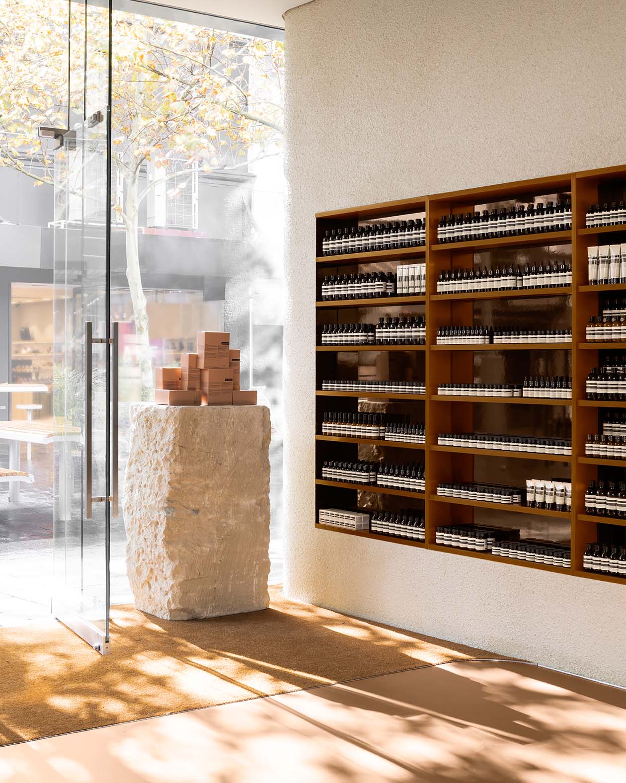 Aesop Perth City interior with glass door and wooden shelves displaying Aesop products 