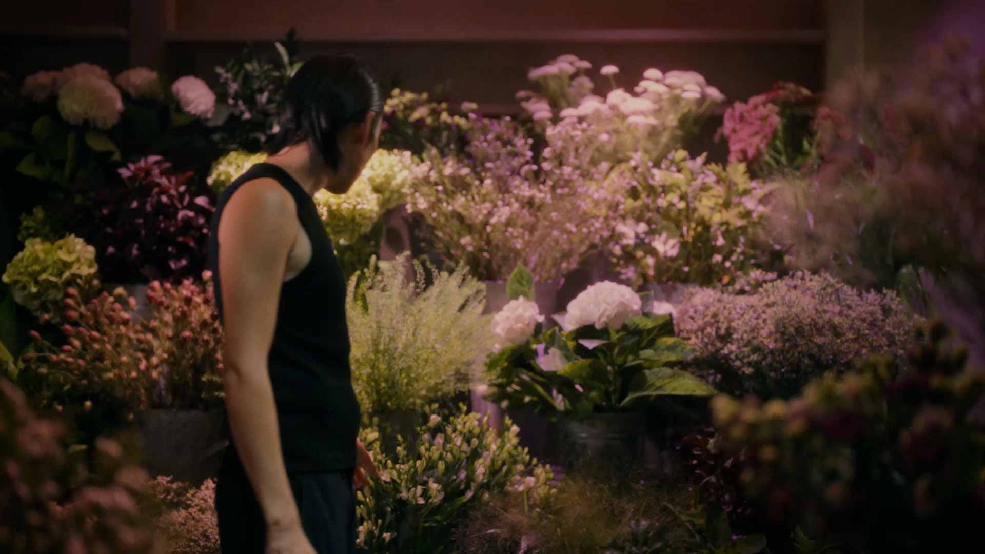 A person inspecting a floral arrangement.