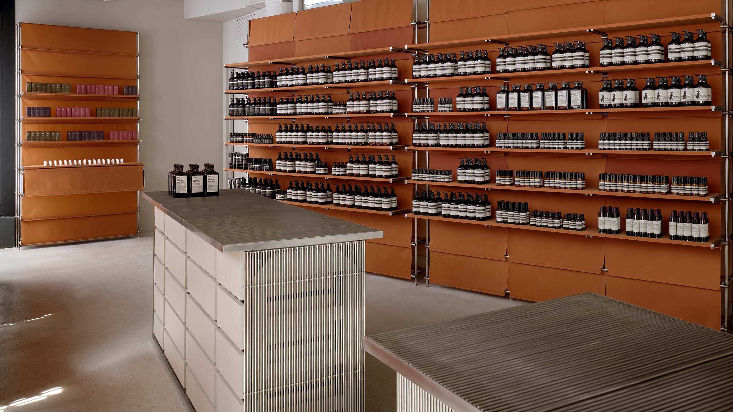 store interior featuring wooden wall with product shelves and counters made of thin steel bars