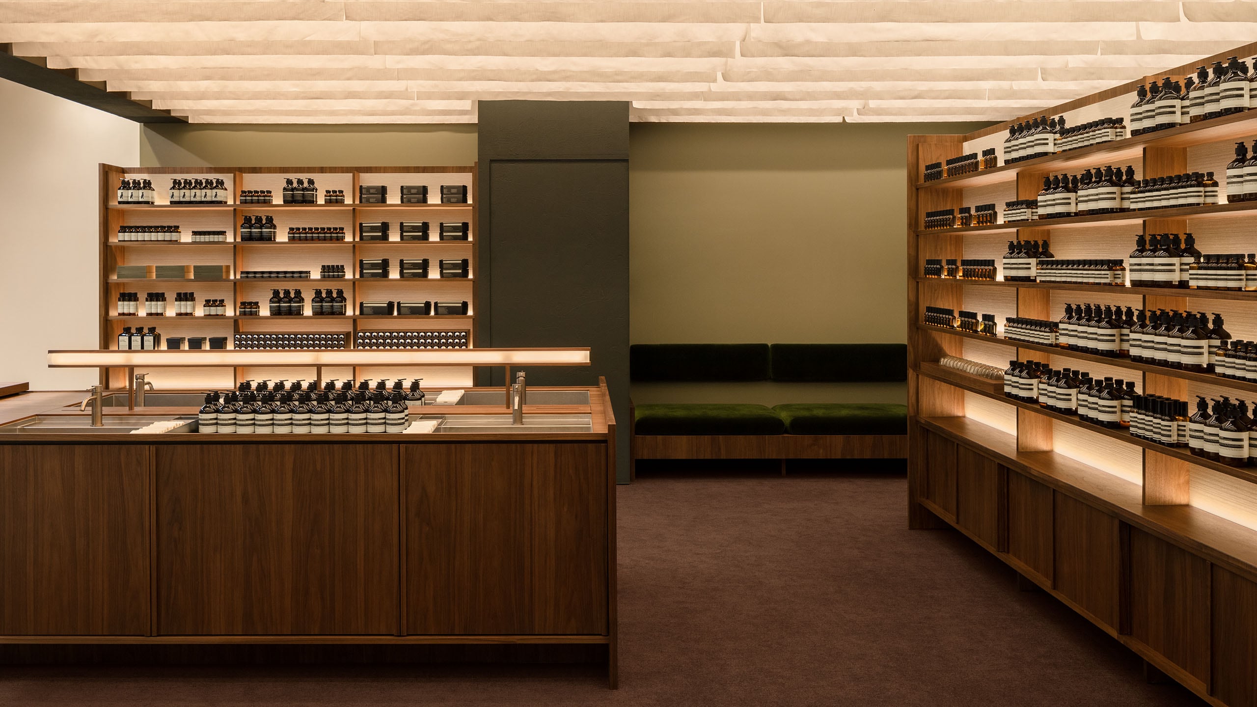 Strips of woven cotton are hung from the ceiling, quartet of basins at the central, surrounded by wide range of Aesop products