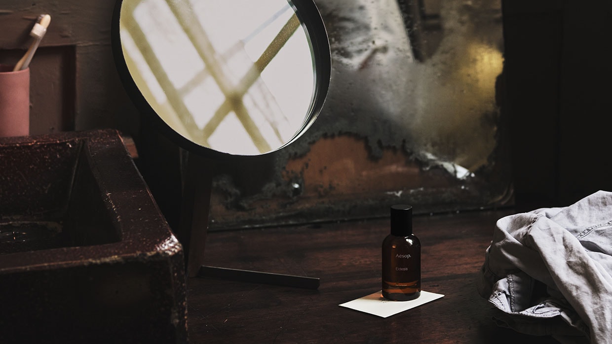 aesop fragrance bottle sitting on desk surrounded by other desk items