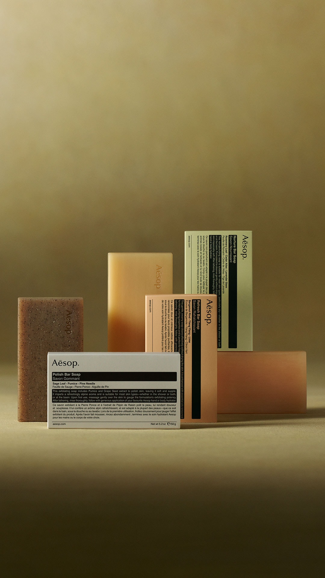 Aesop bar soaps placed next to each other on a green textured background
