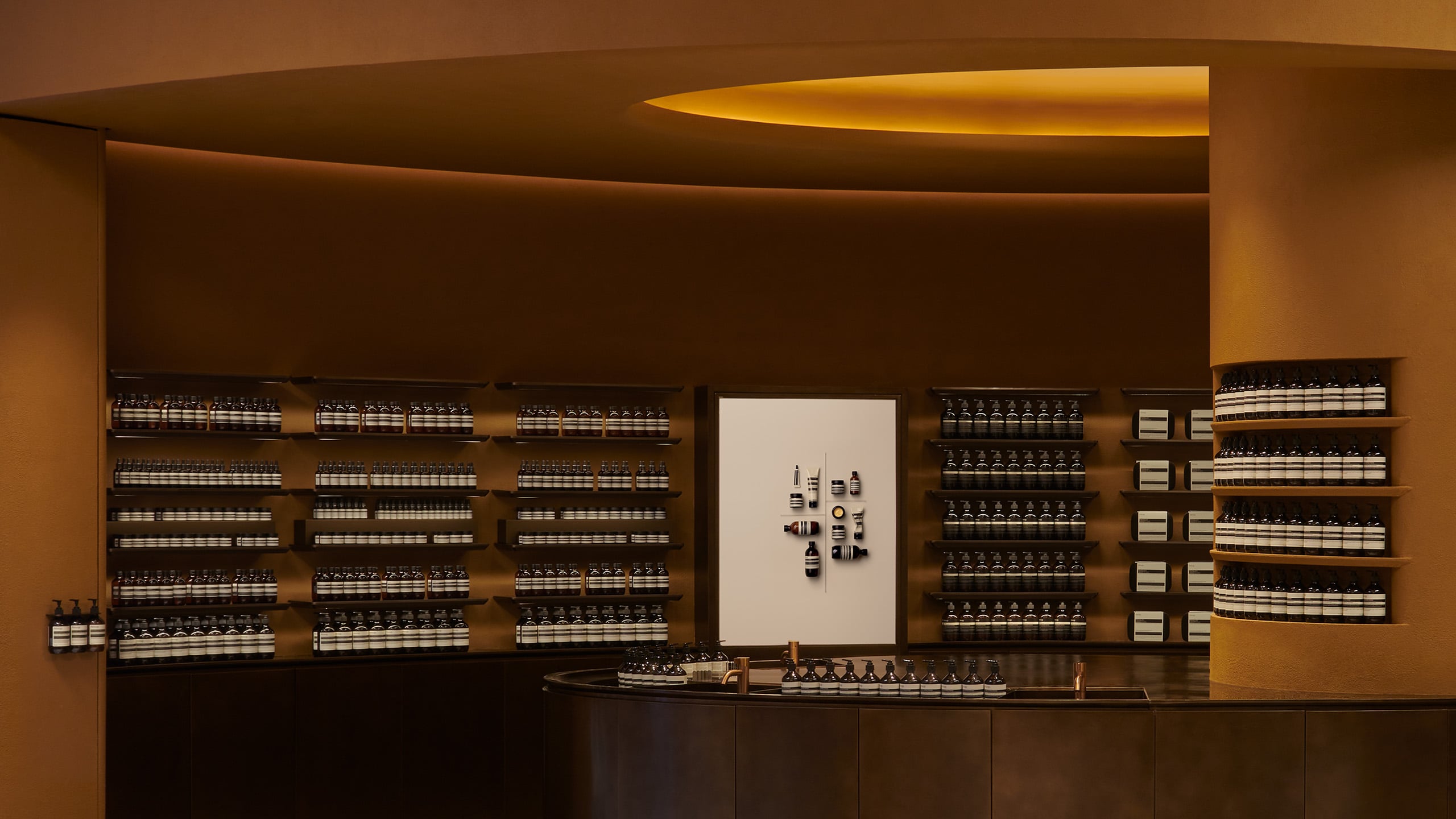 A large basin curves around the central column showcasing the formulations for the skin, hair and body care