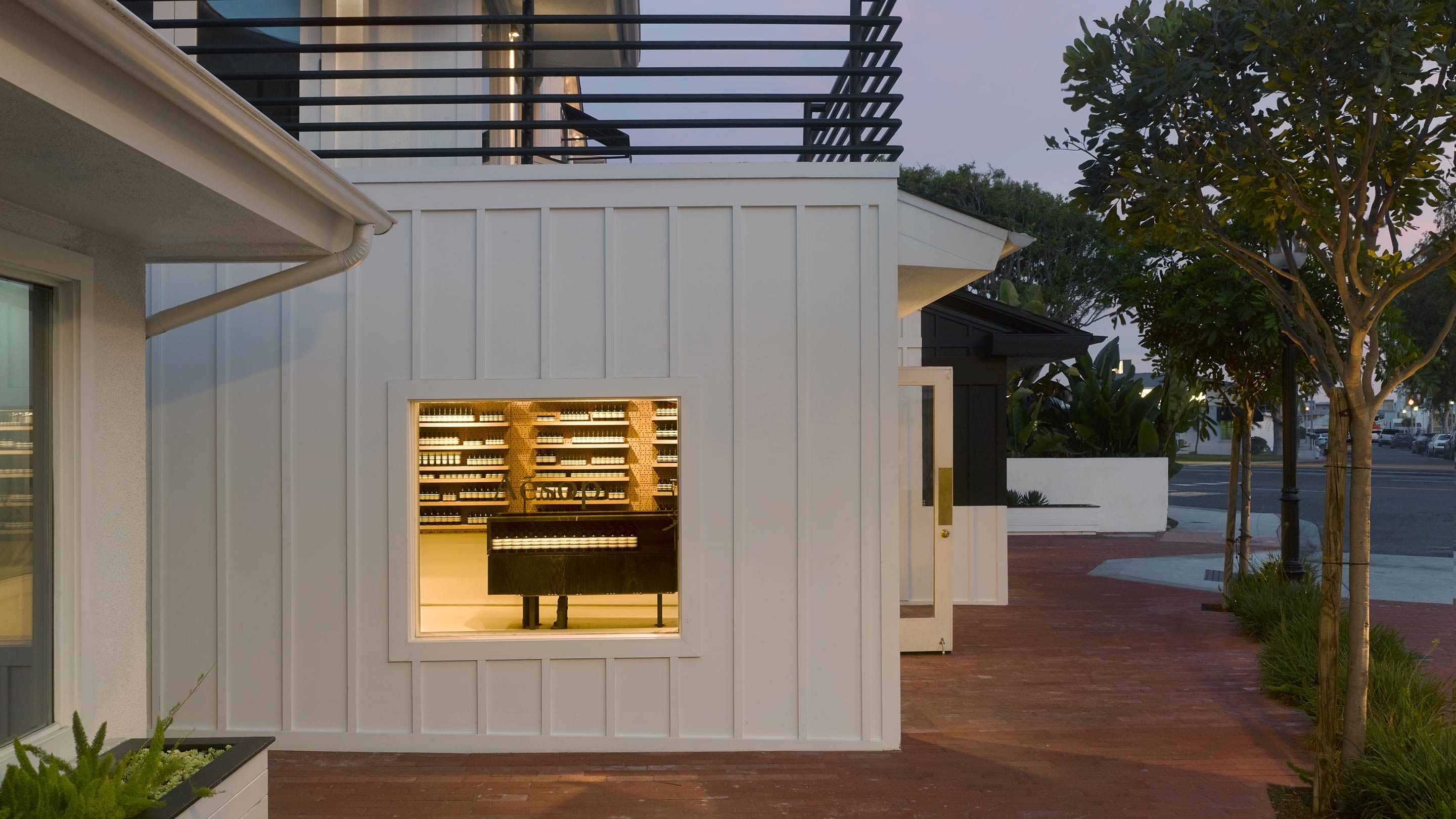 Aesop Lido Marina's shopfront, with a small square window providing a glimpse of what is inside.