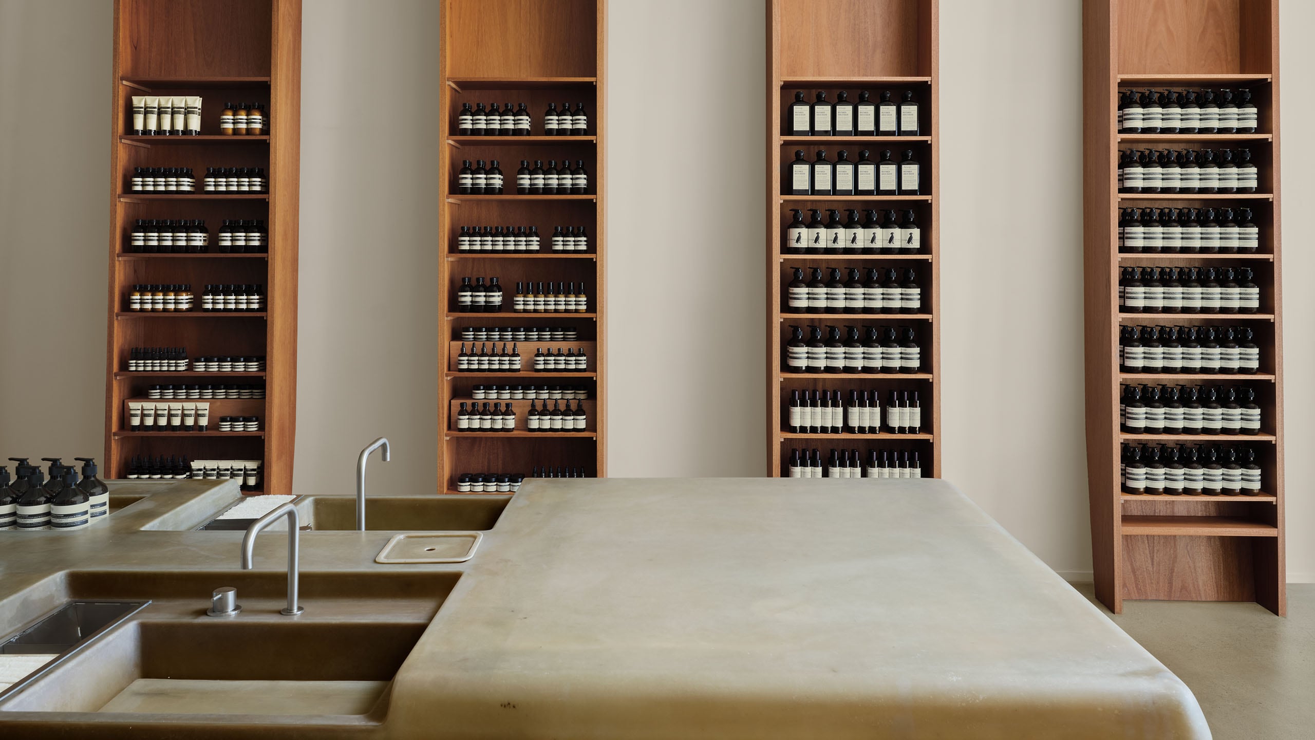 store interior shot featuring white and copper basin unit with wooden product shelving units on walls